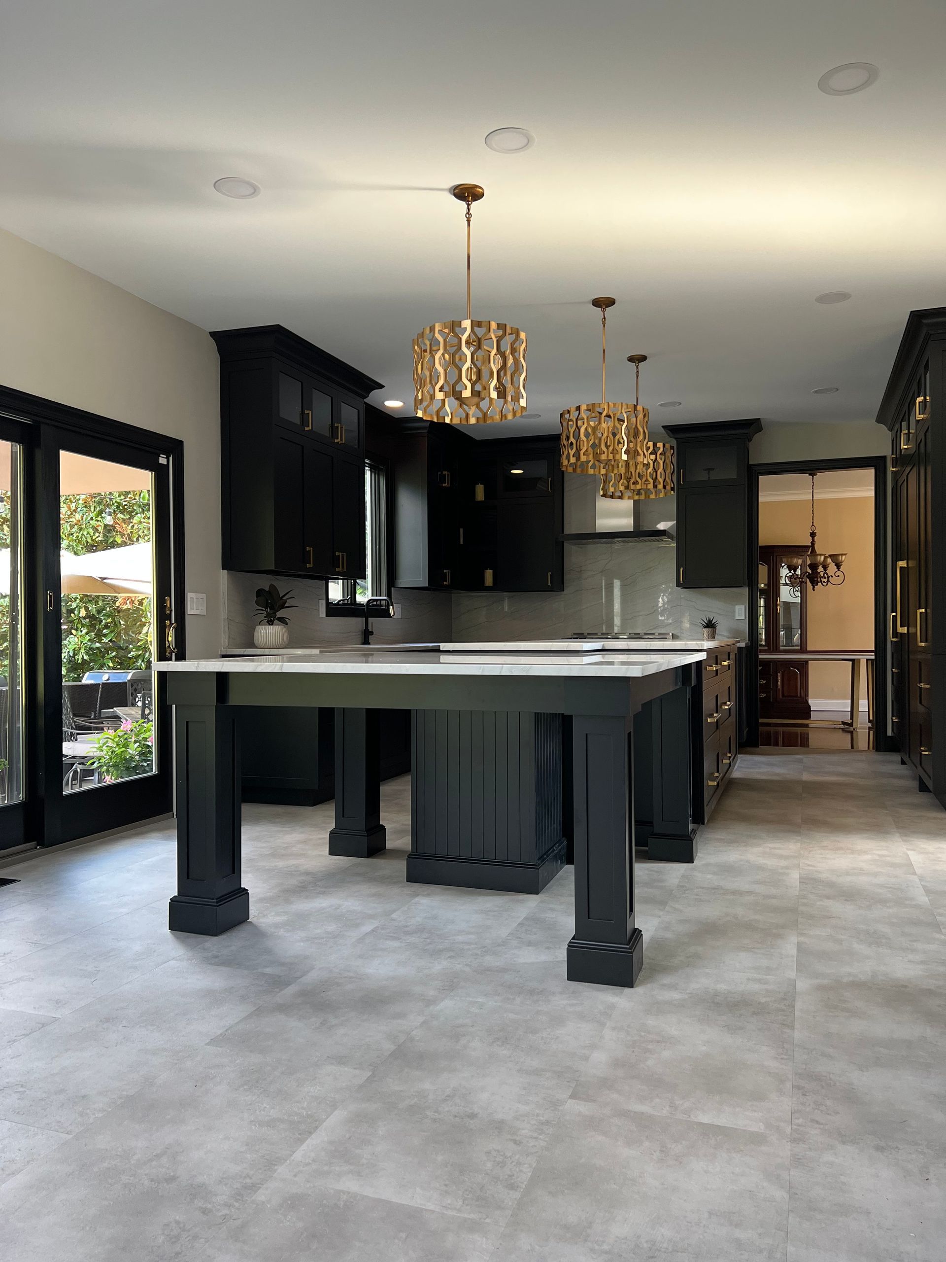 A kitchen with black cabinets and a large island
