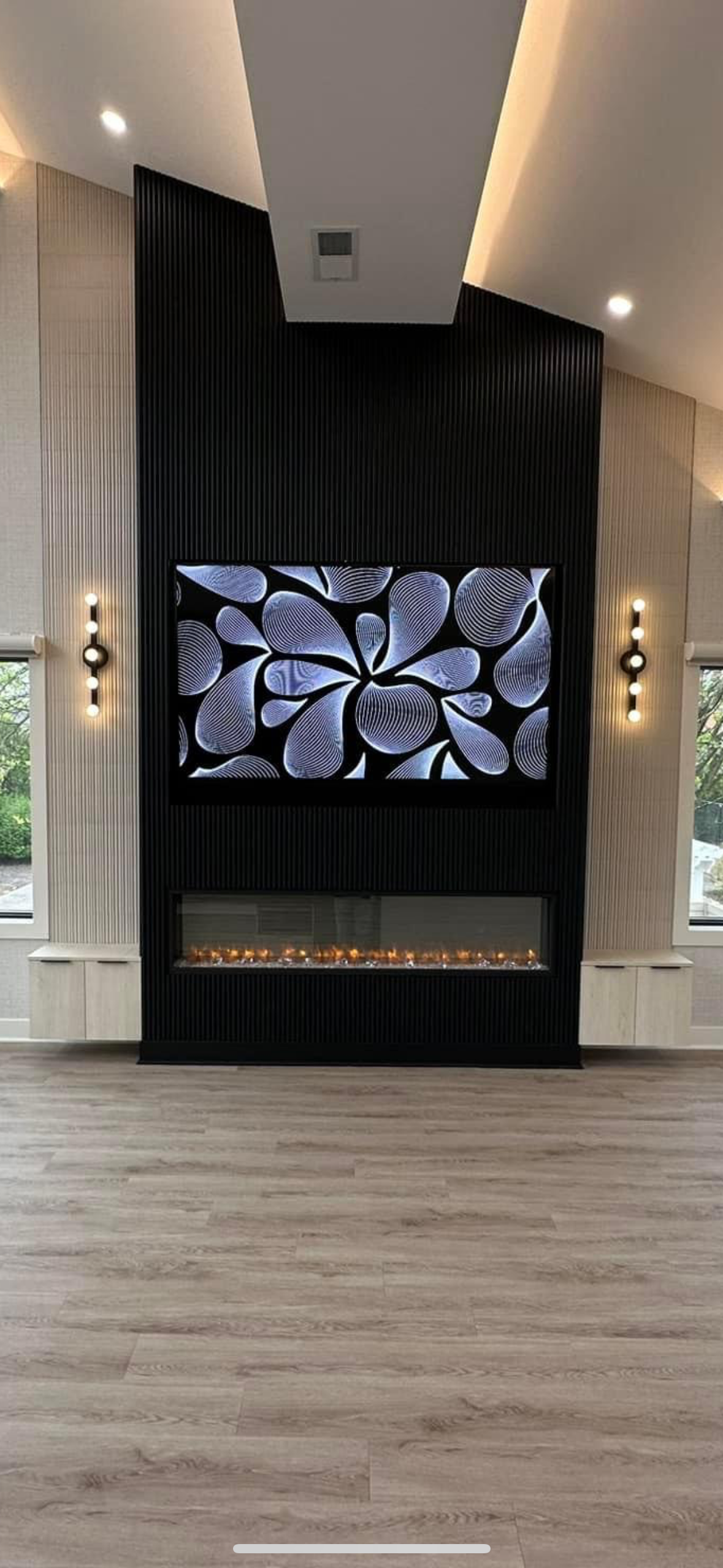 A living room with a fireplace and a flat screen tv on the wall.