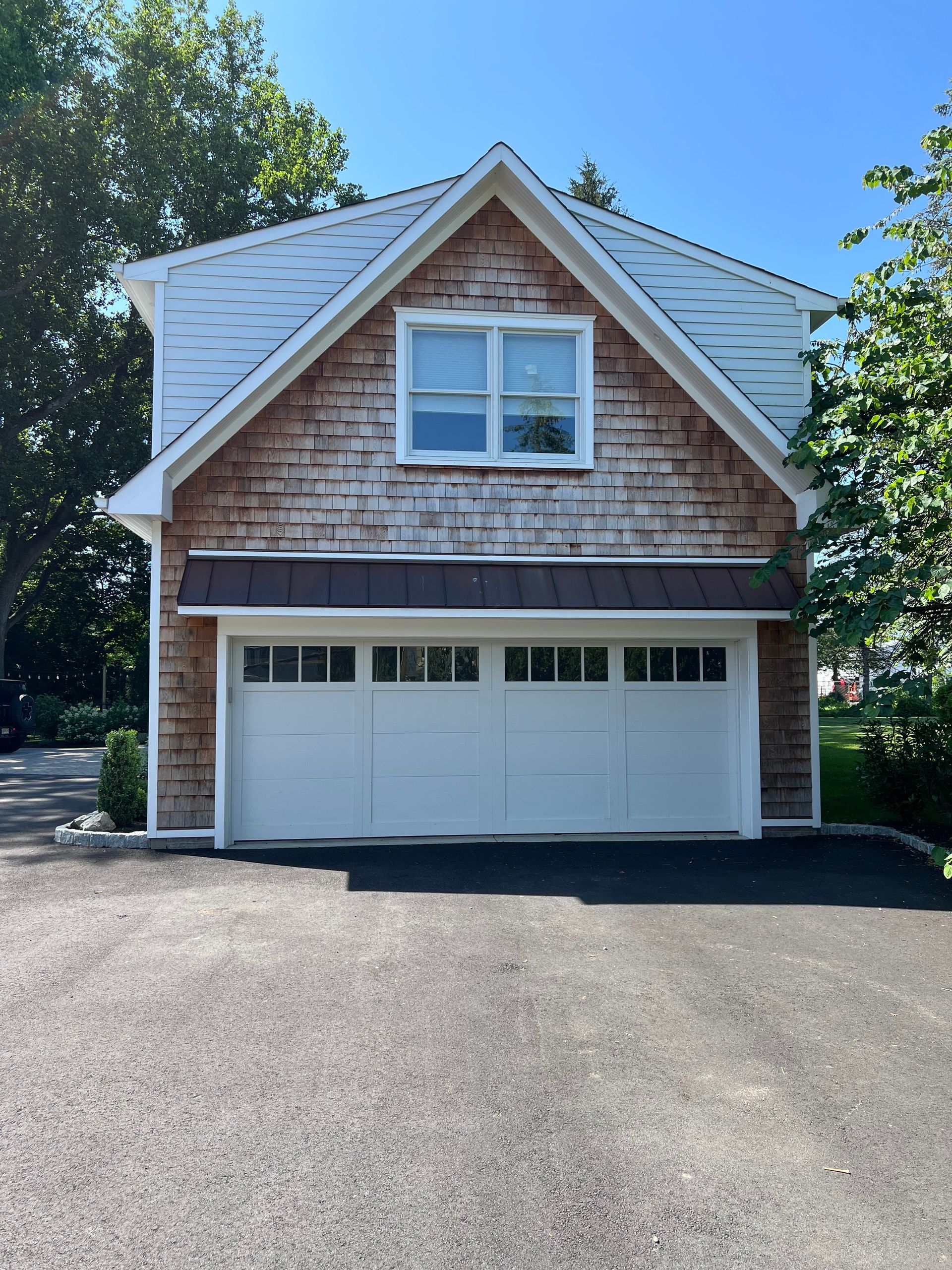 A garage with a white door and a brown roof