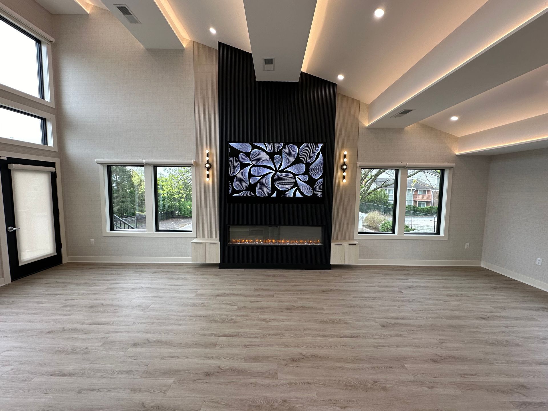 A living room with a fireplace and a flat screen tv on the wall.