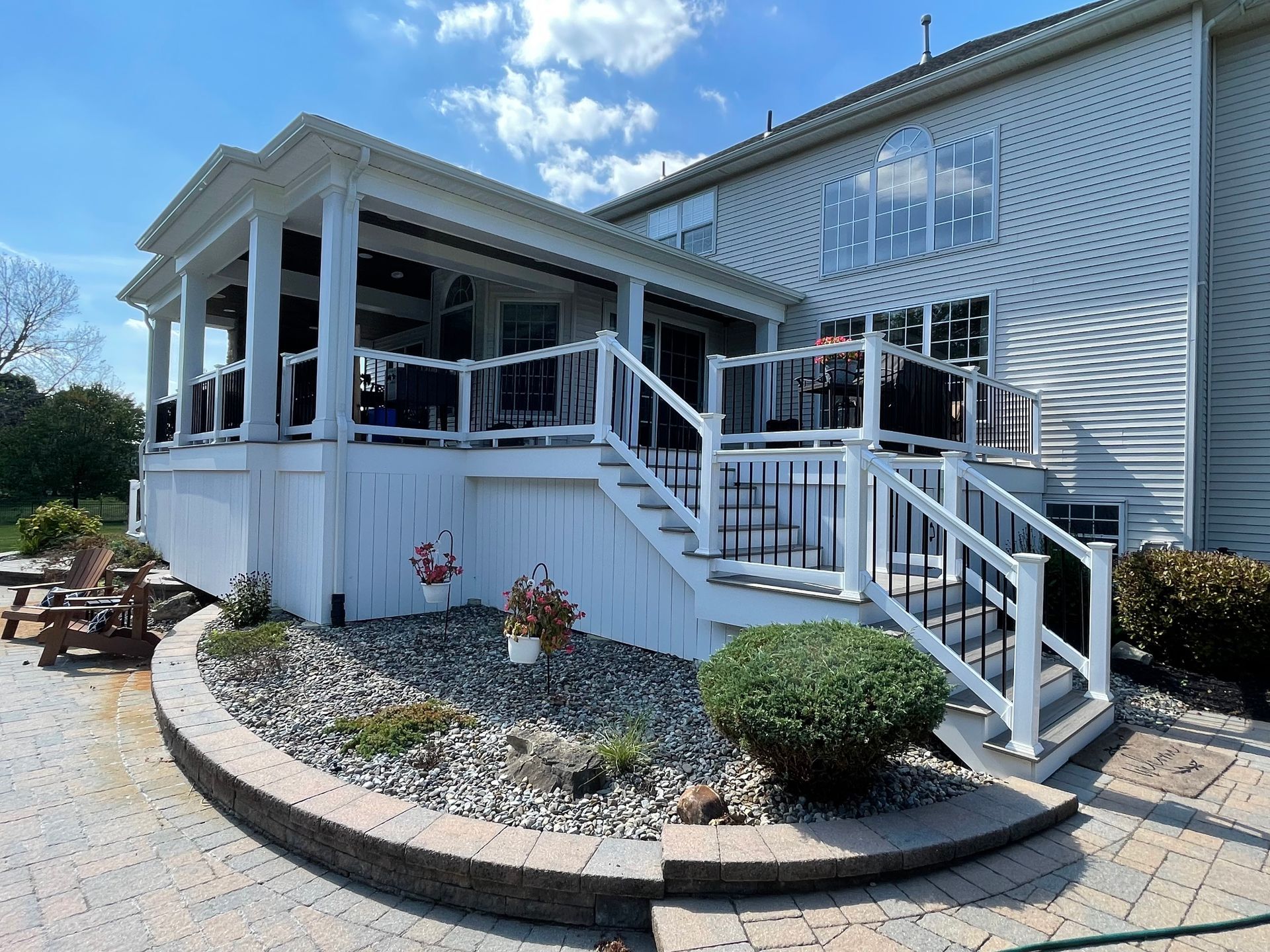 A white house with a large porch and stairs leading up to it.