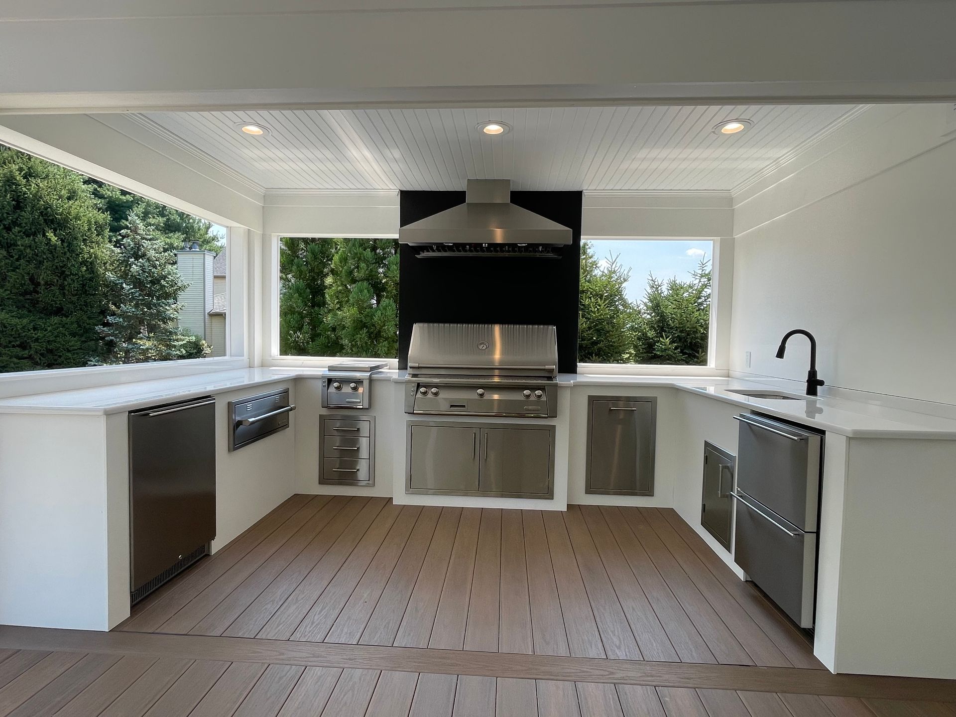 A kitchen with stainless steel appliances and white counter tops