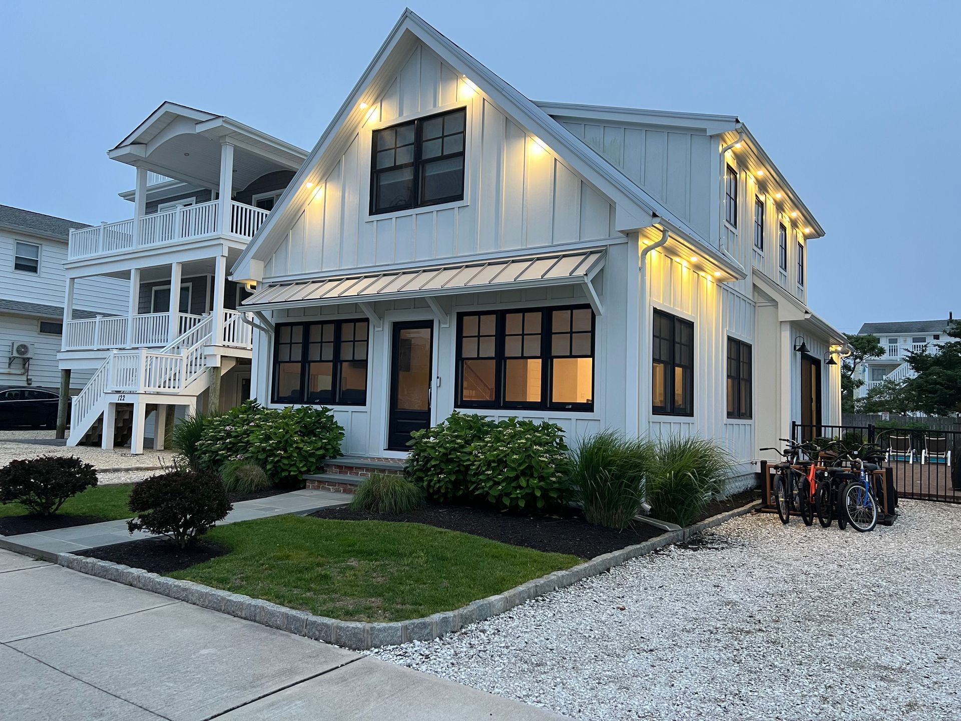 A white house with a lot of windows is lit up at night.