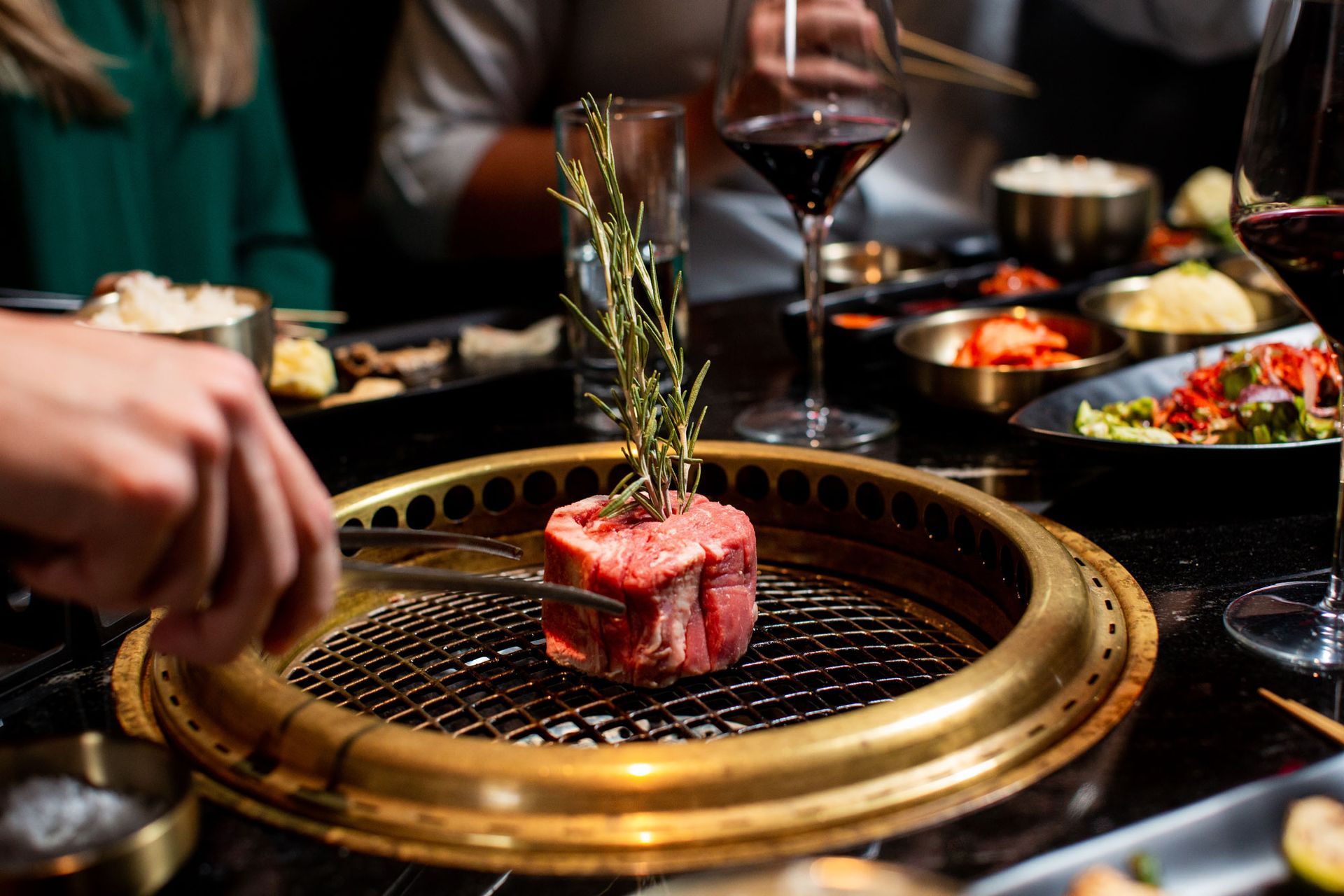 A person is cutting a piece of meat on a grill.