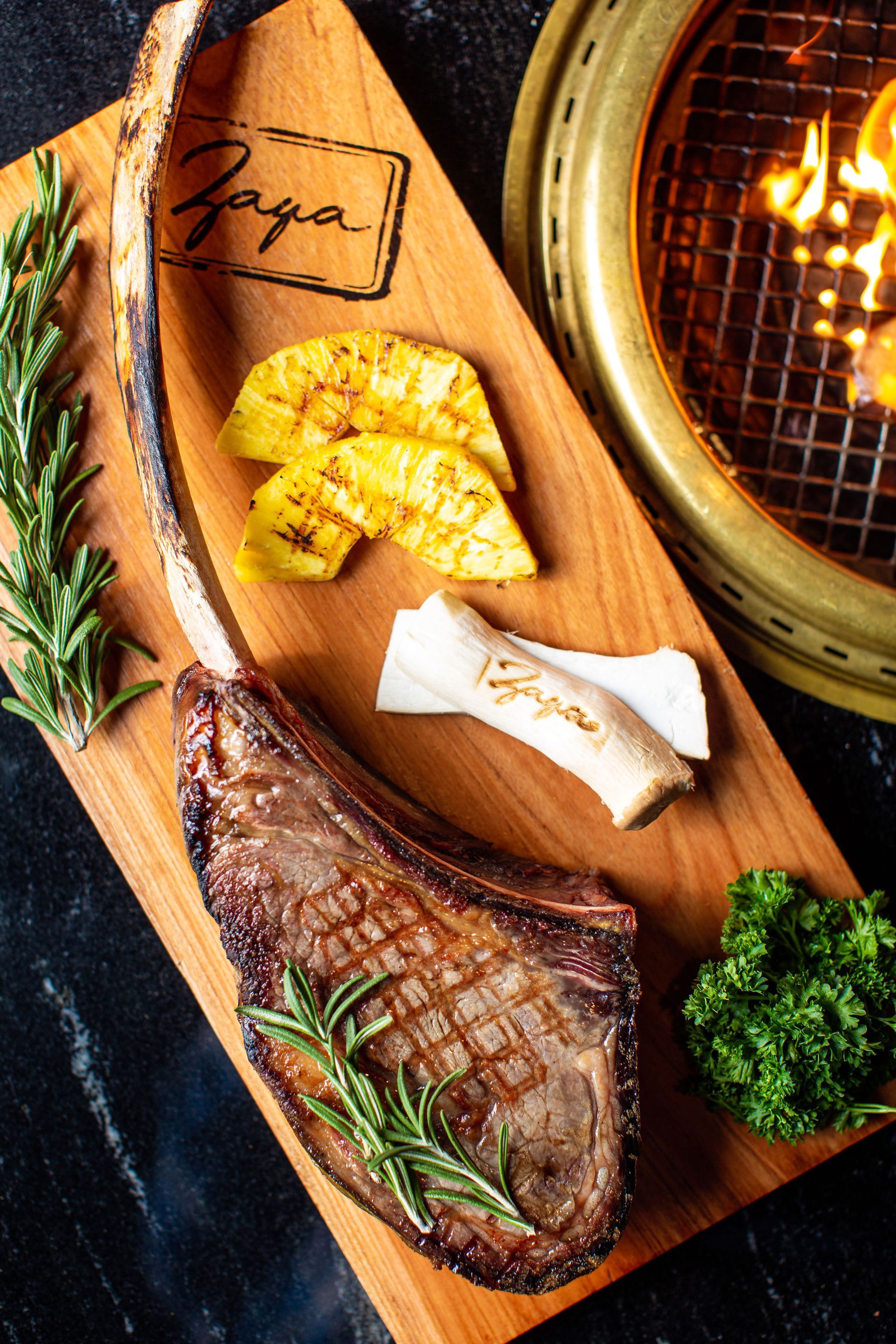 A steak is sitting on a wooden cutting board next to a grill.