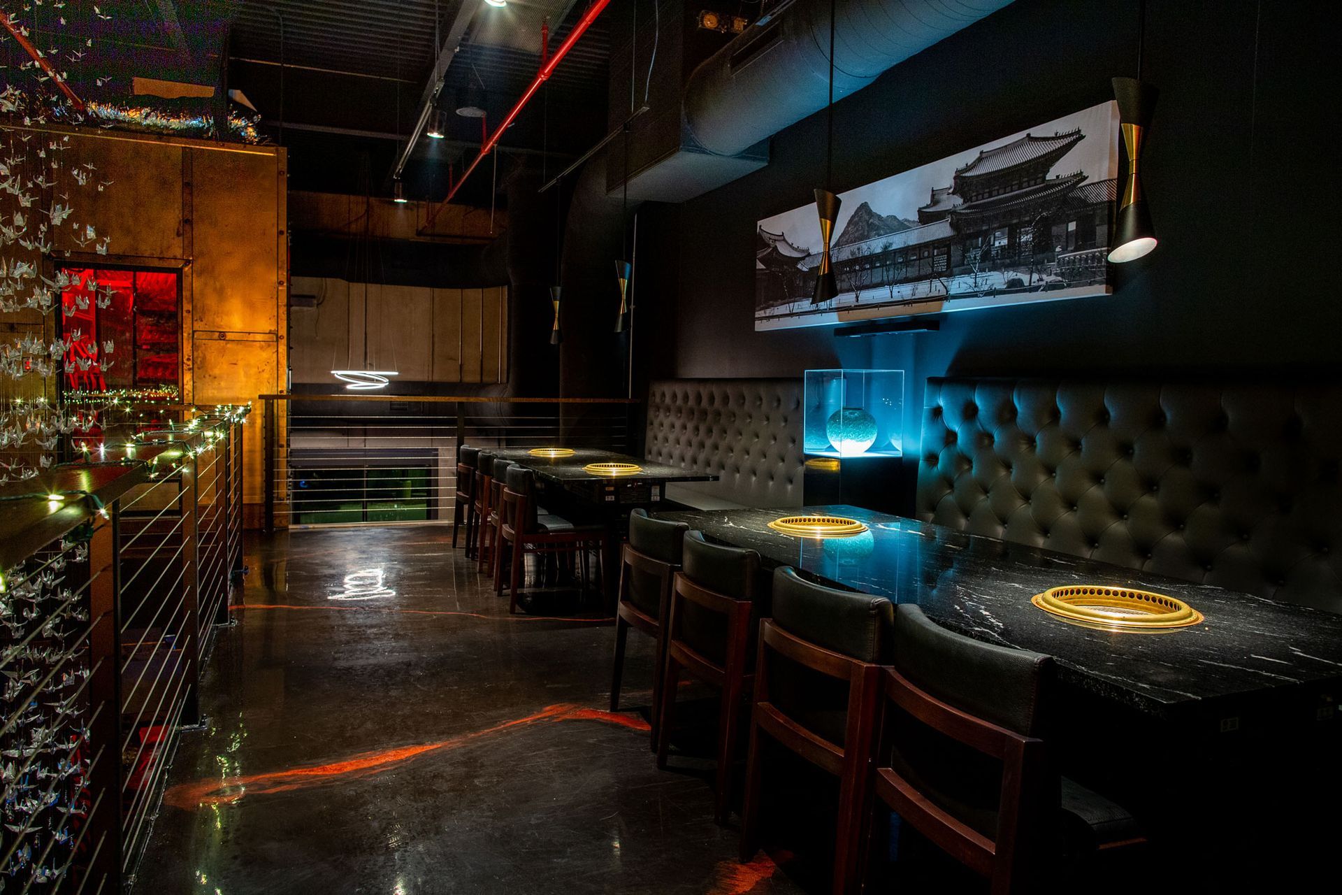 A restaurant with tables and chairs in a dark room.
