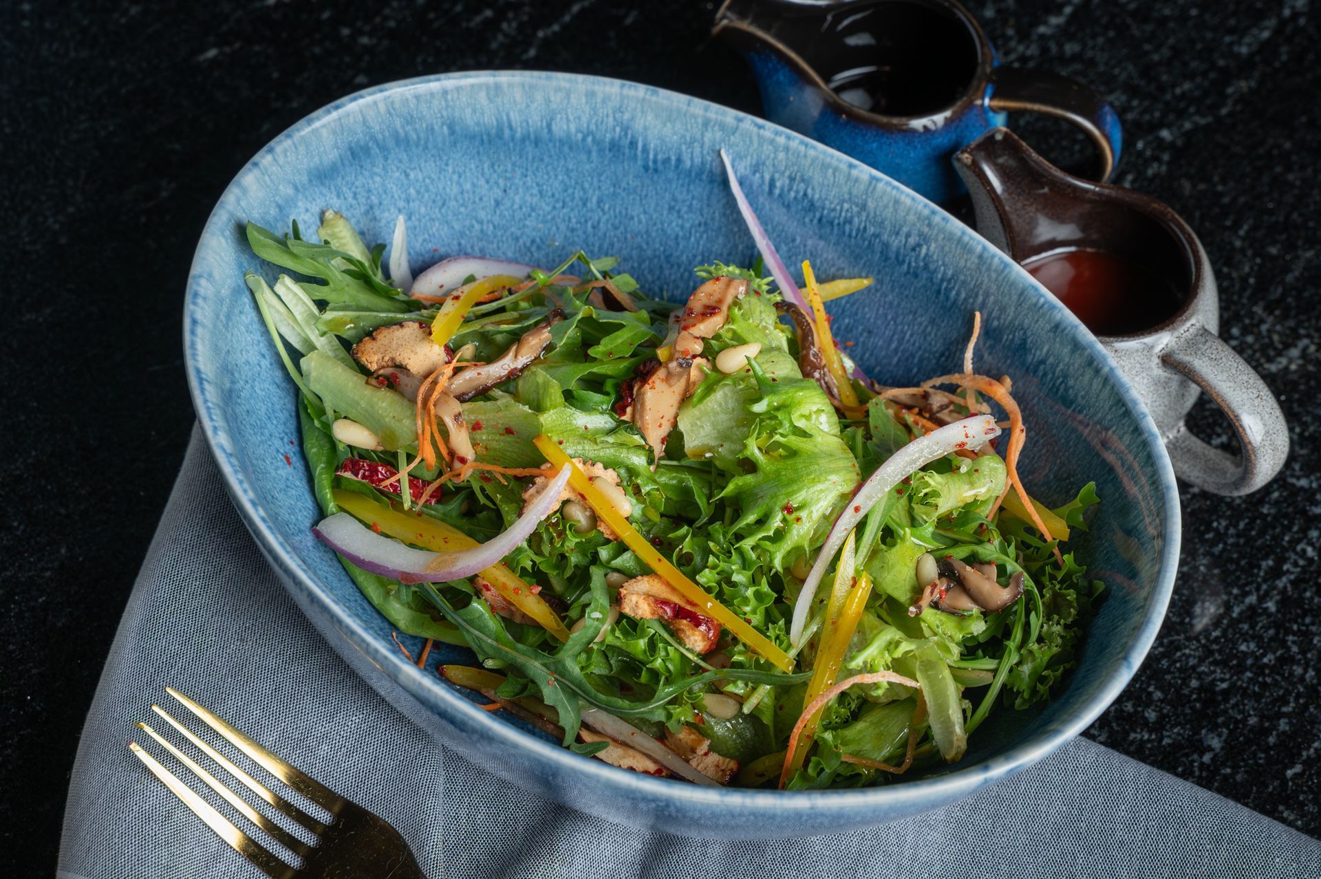 Korean bibimbap bowl with rice, vegetables, egg yolk, and sauce on a table