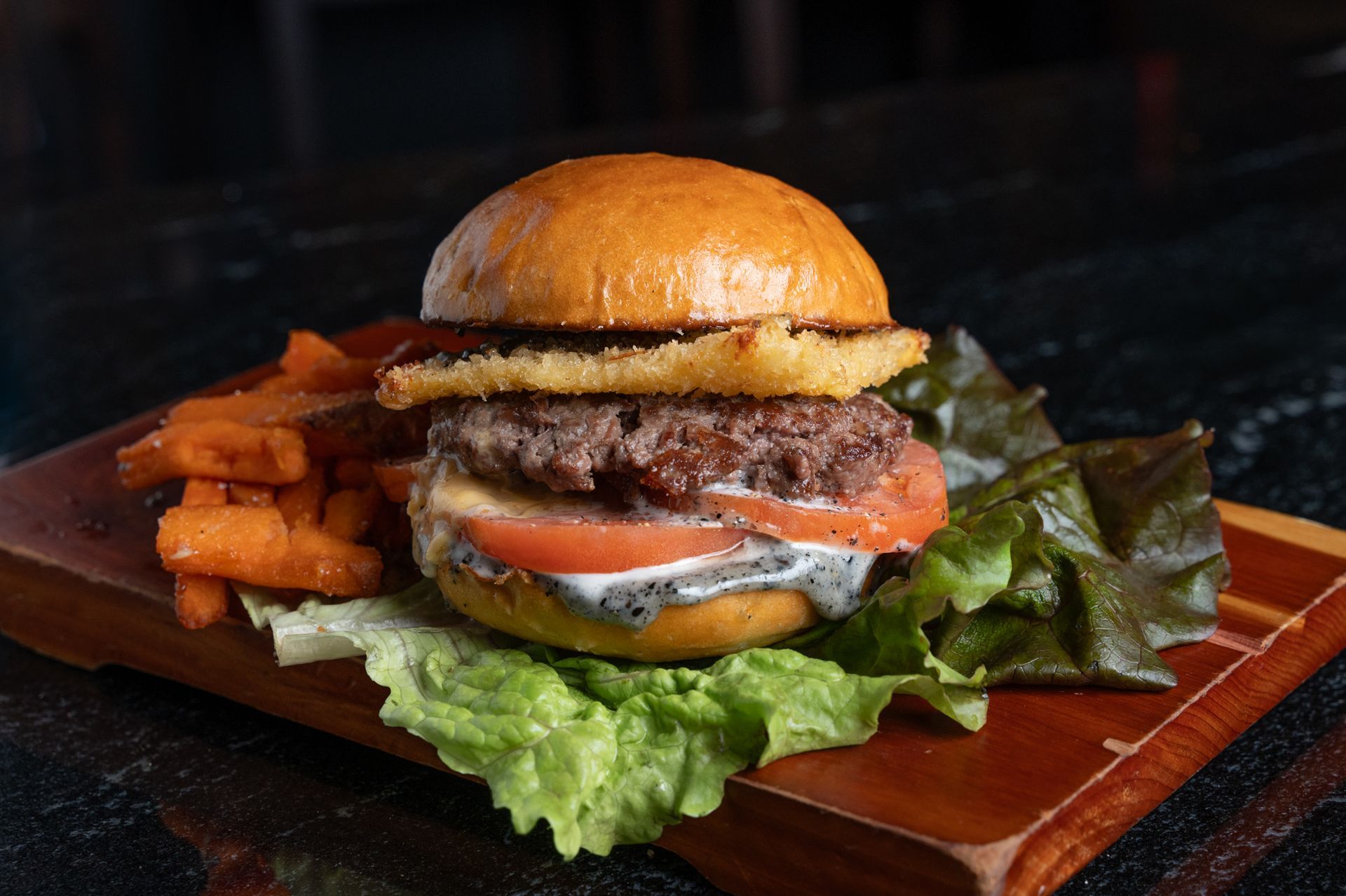 A sandwich and French fries on a white plate on a table.
