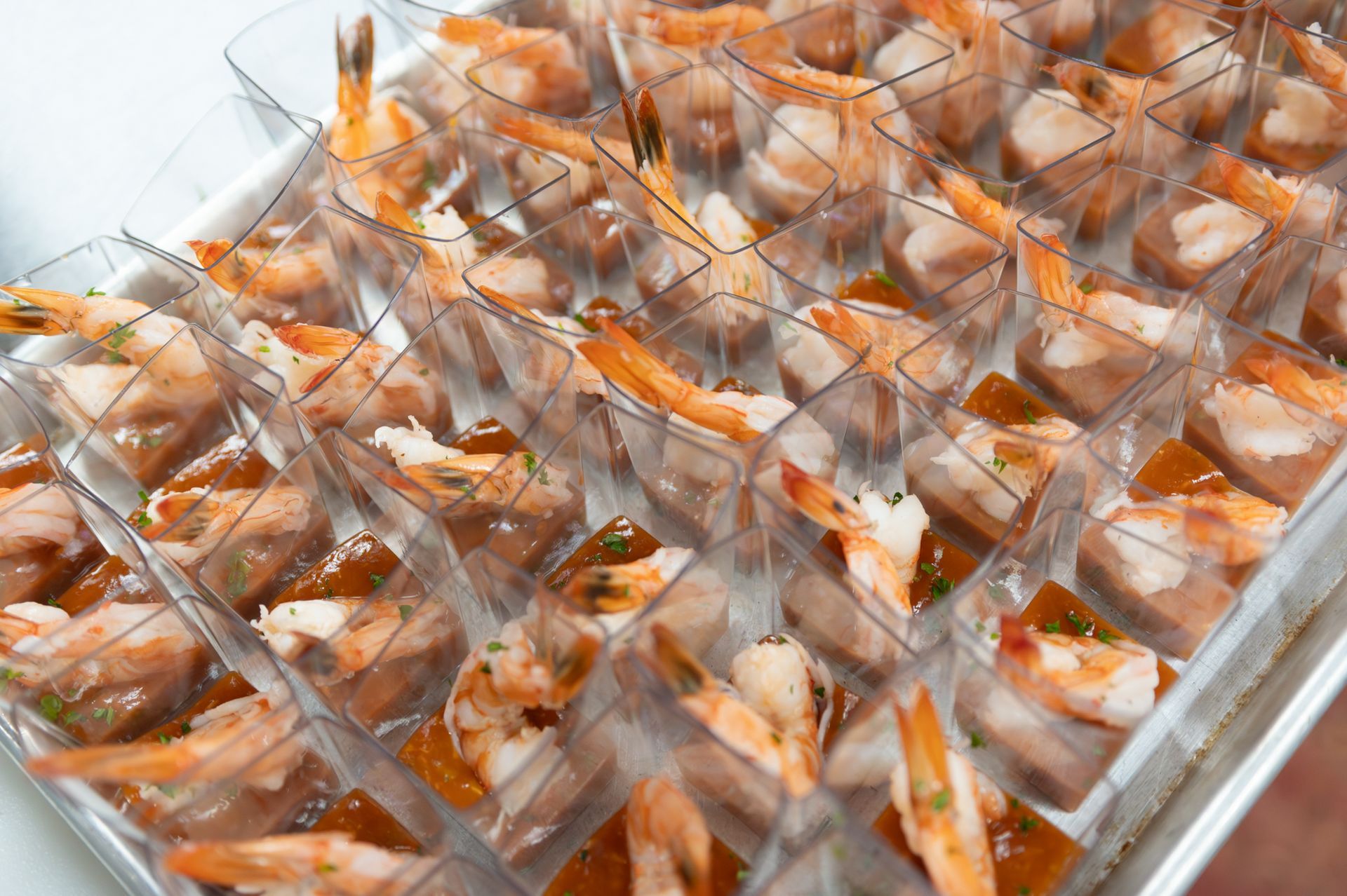 Tray of individually wrapped orange-and-white pastries arranged in rows