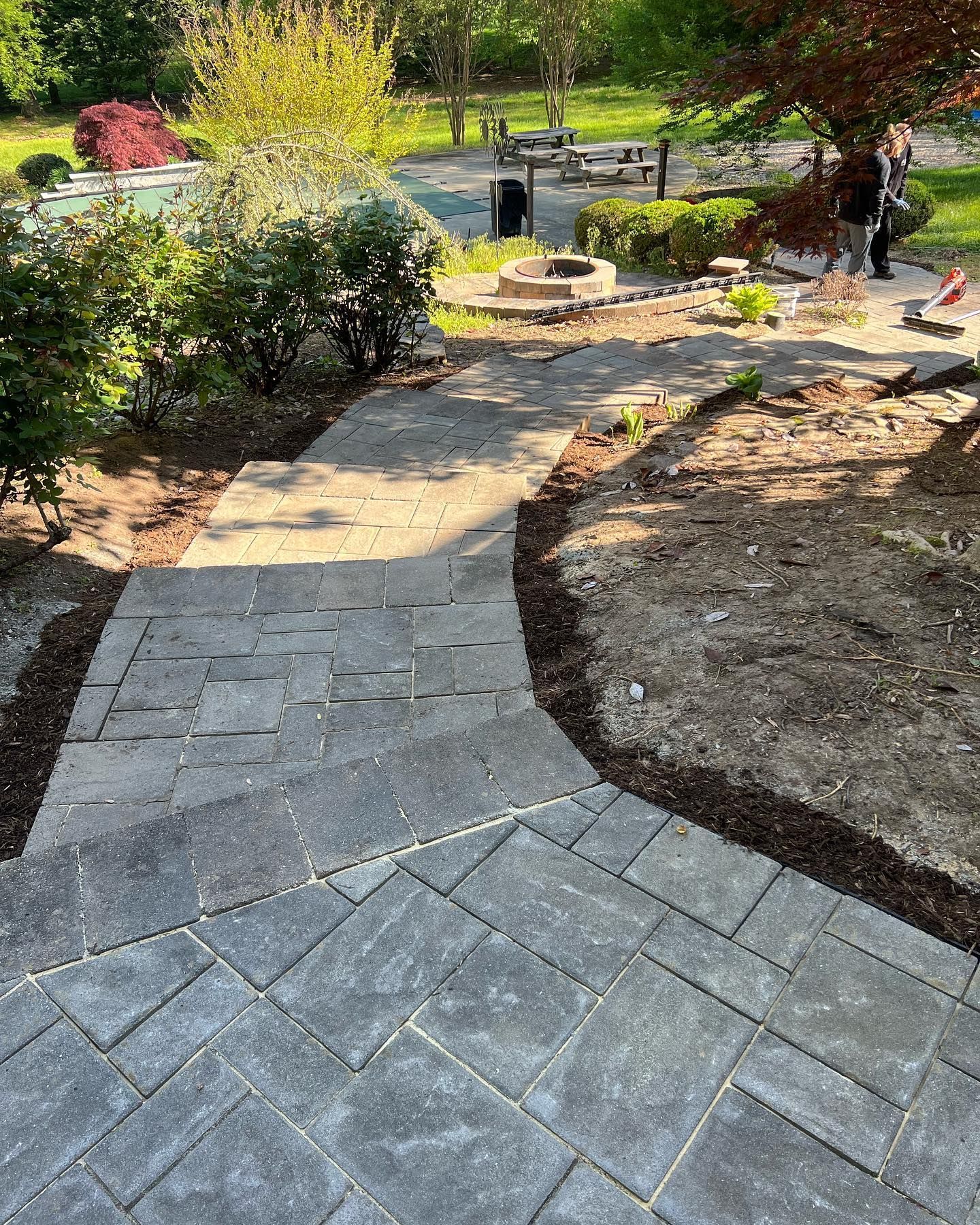 a concrete walkway leading to a pool in a backyard .