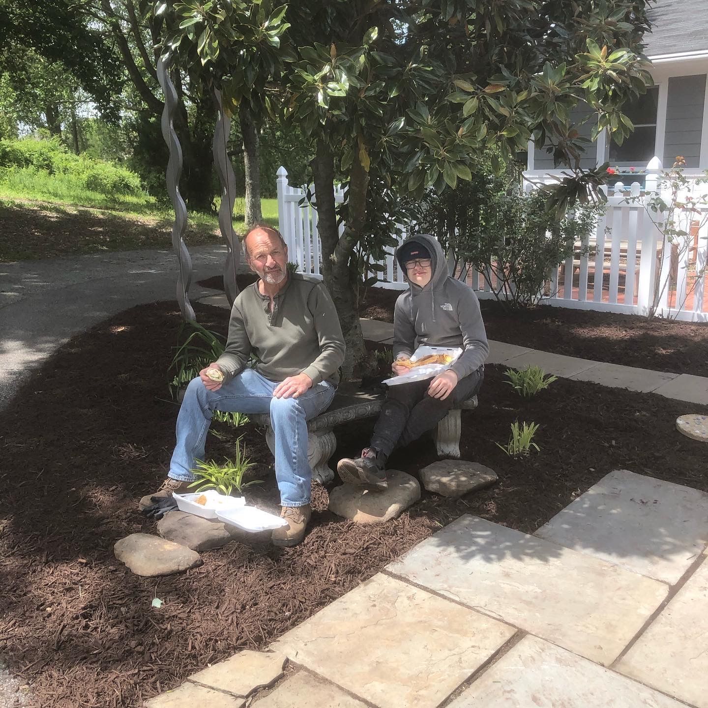 a man and a boy are sitting under a tree