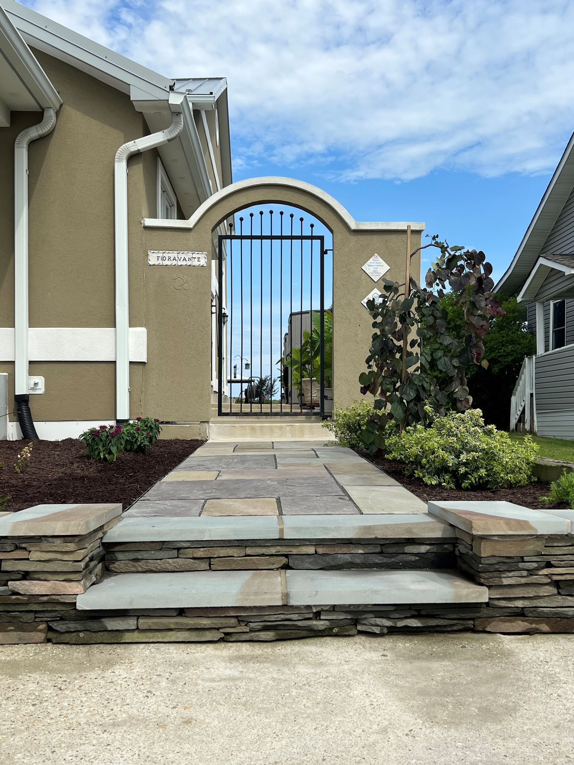 a house with a stone walkway leading to a gate