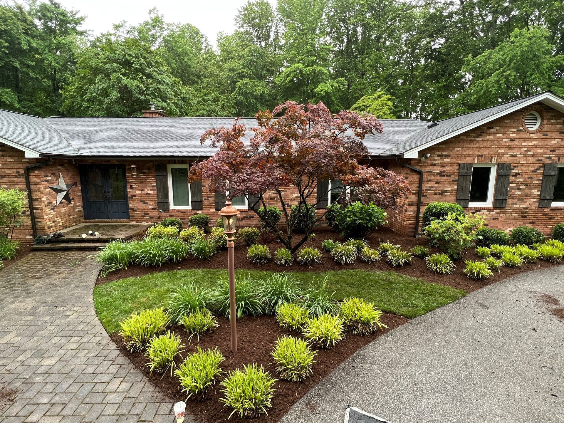 a large brick house with a lot of plants in front of it .