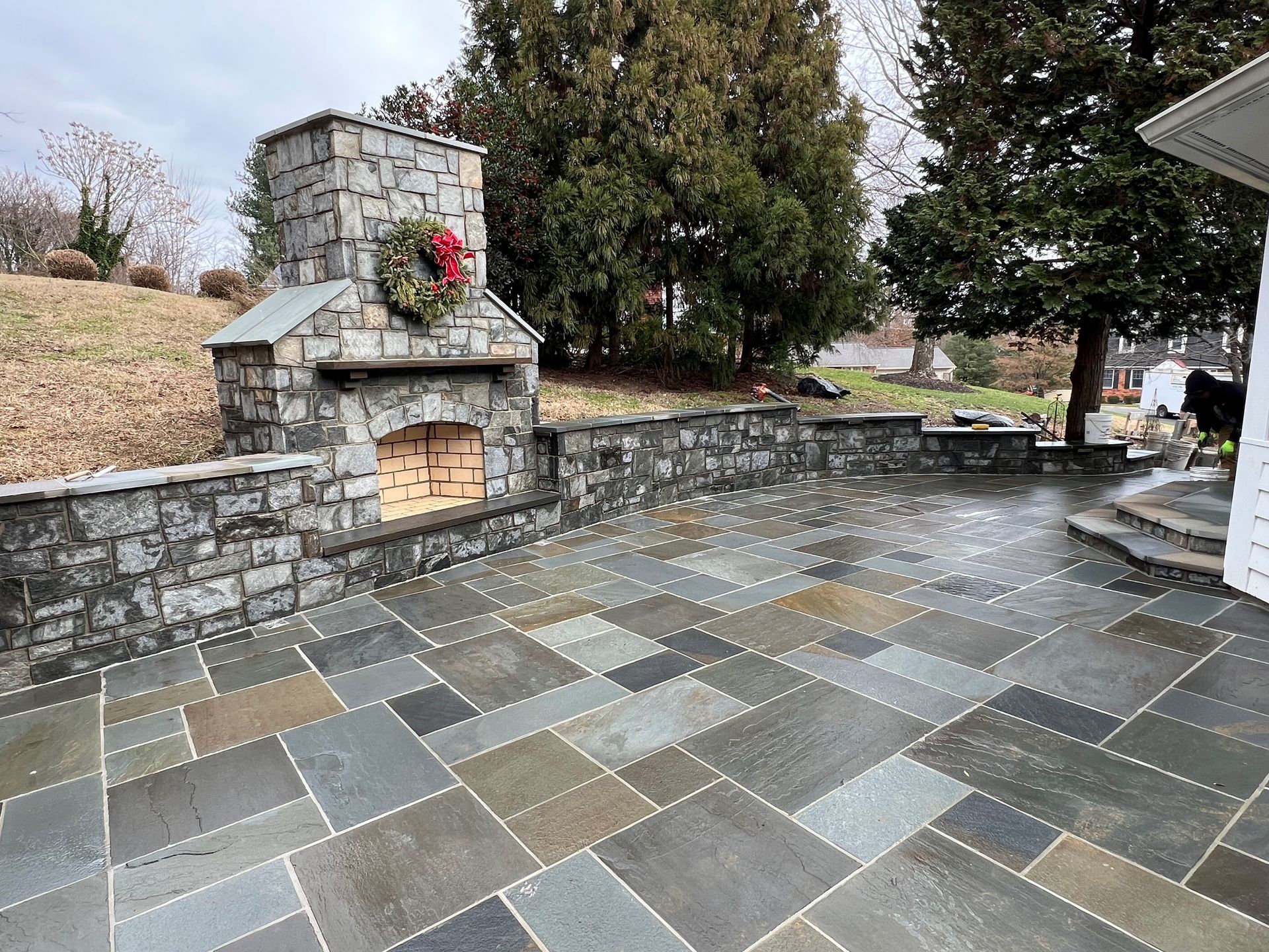 a patio with a stone fireplace and a wreath on it .