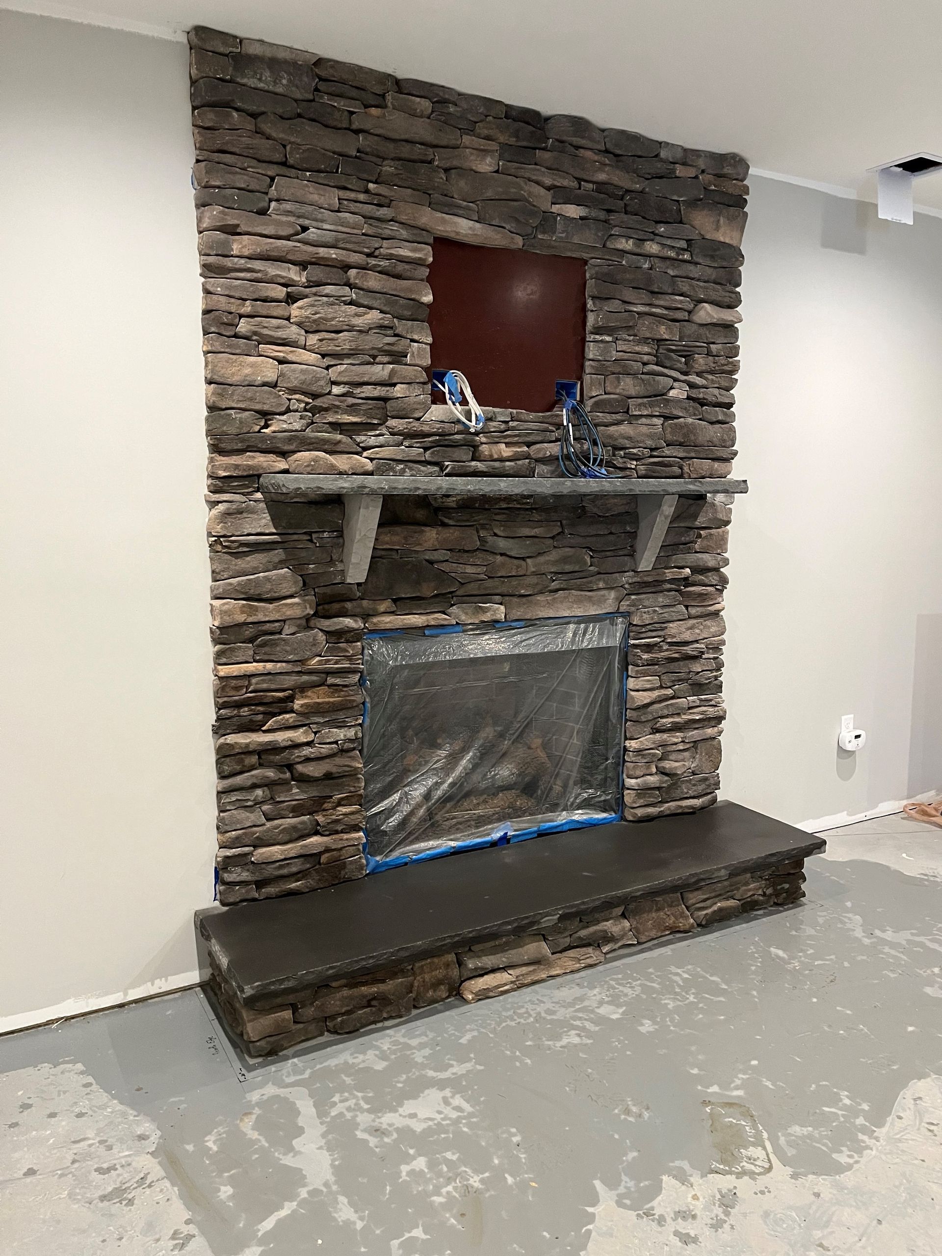 a stone fireplace is being built in a living room .