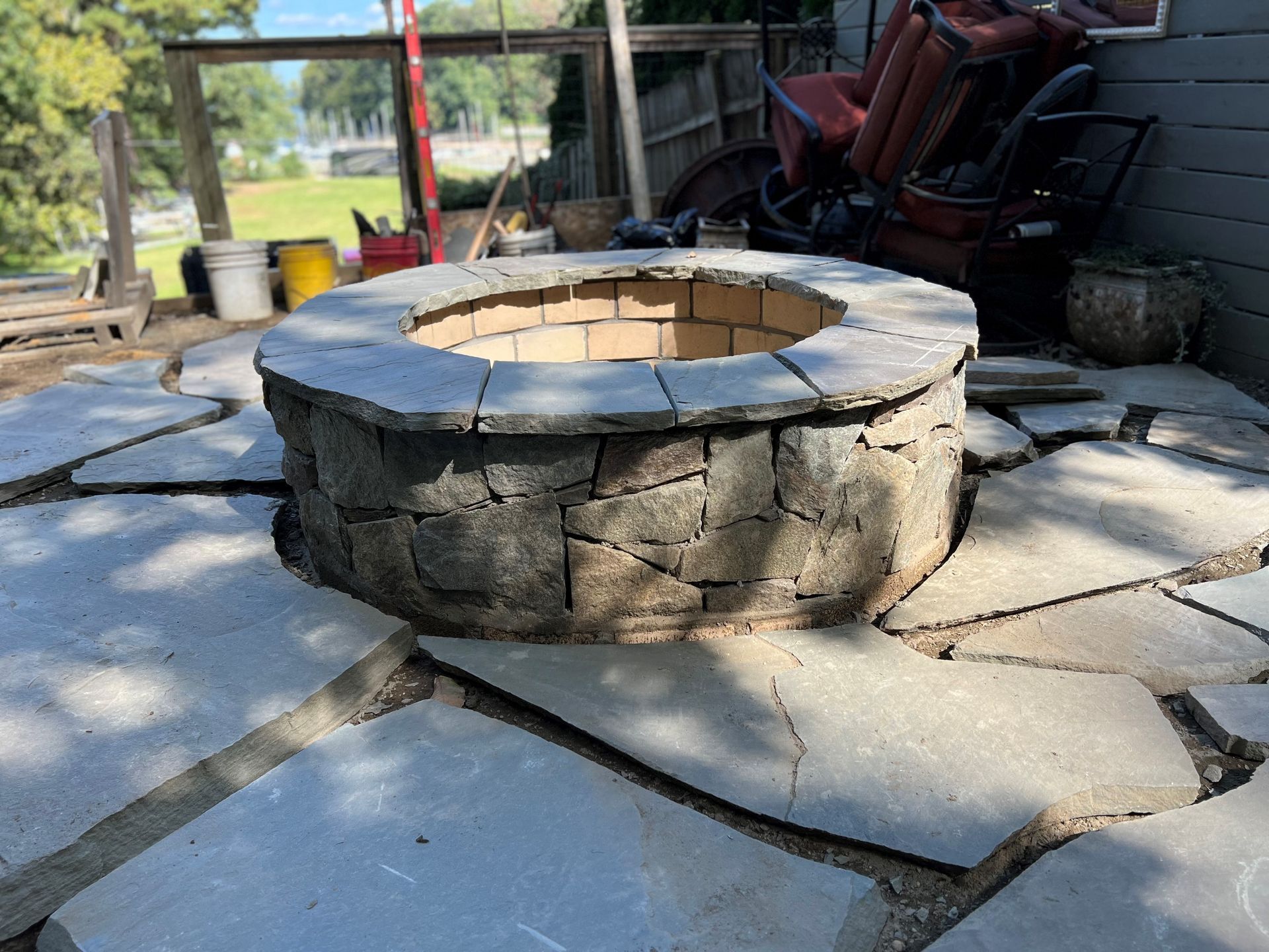 a fire pit is sitting on top of a stone patio .