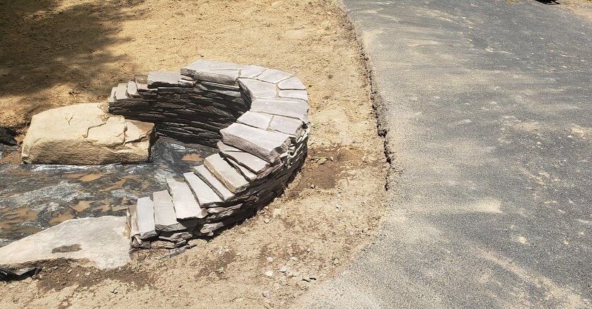 A fire pit is being built in the middle of a dirt road