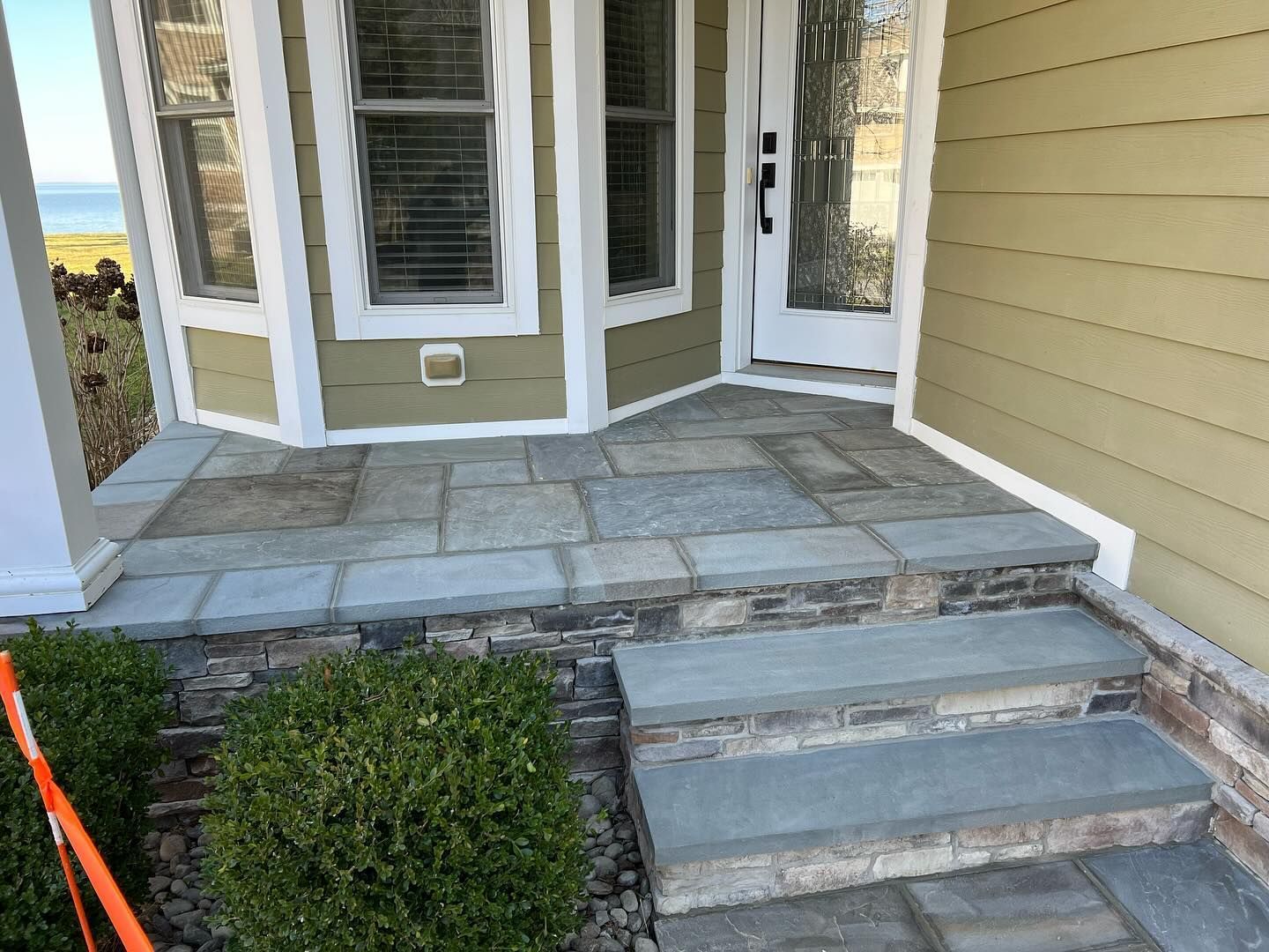 A house with a stone porch and steps leading to the front door