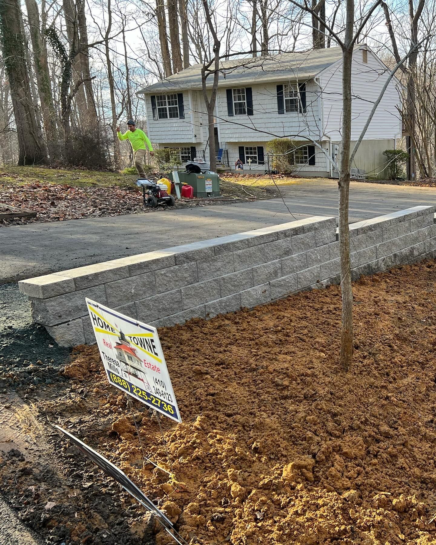 A brick wall is being built in front of a house