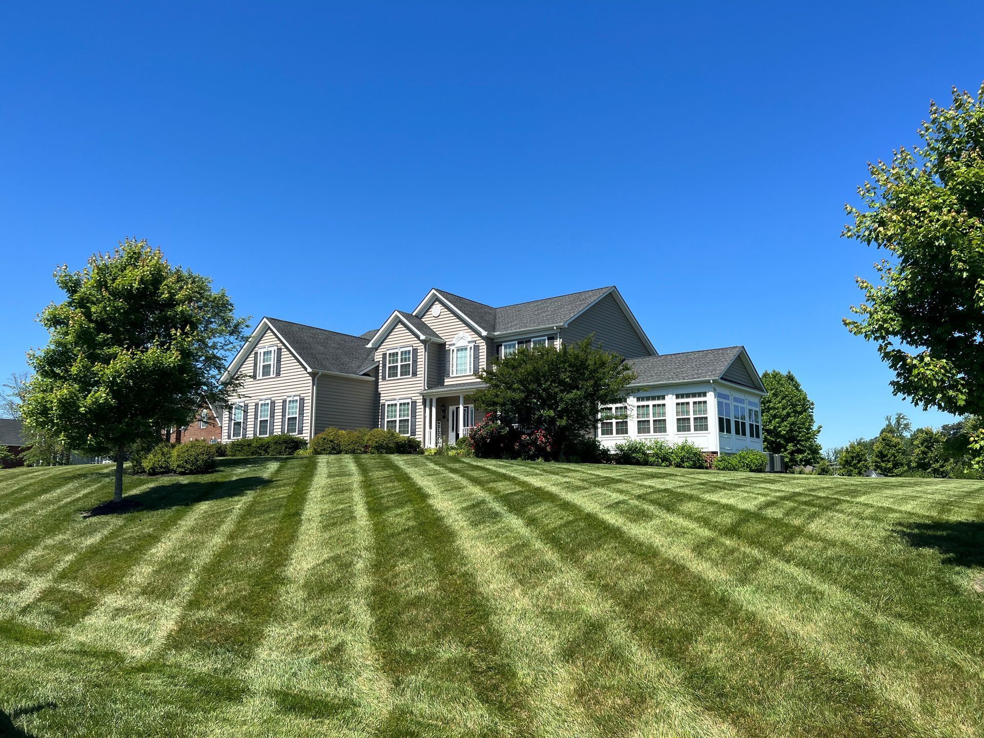 a large house with a lush green lawn in front of it .