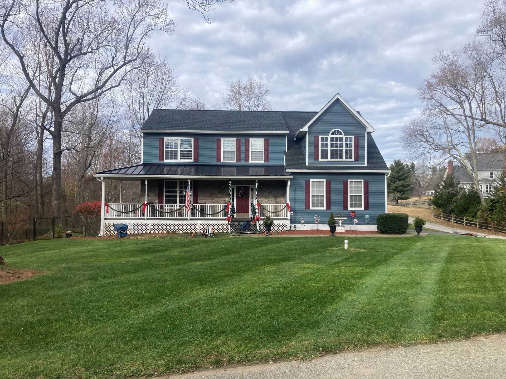 A blue house with a large lawn in front of it.