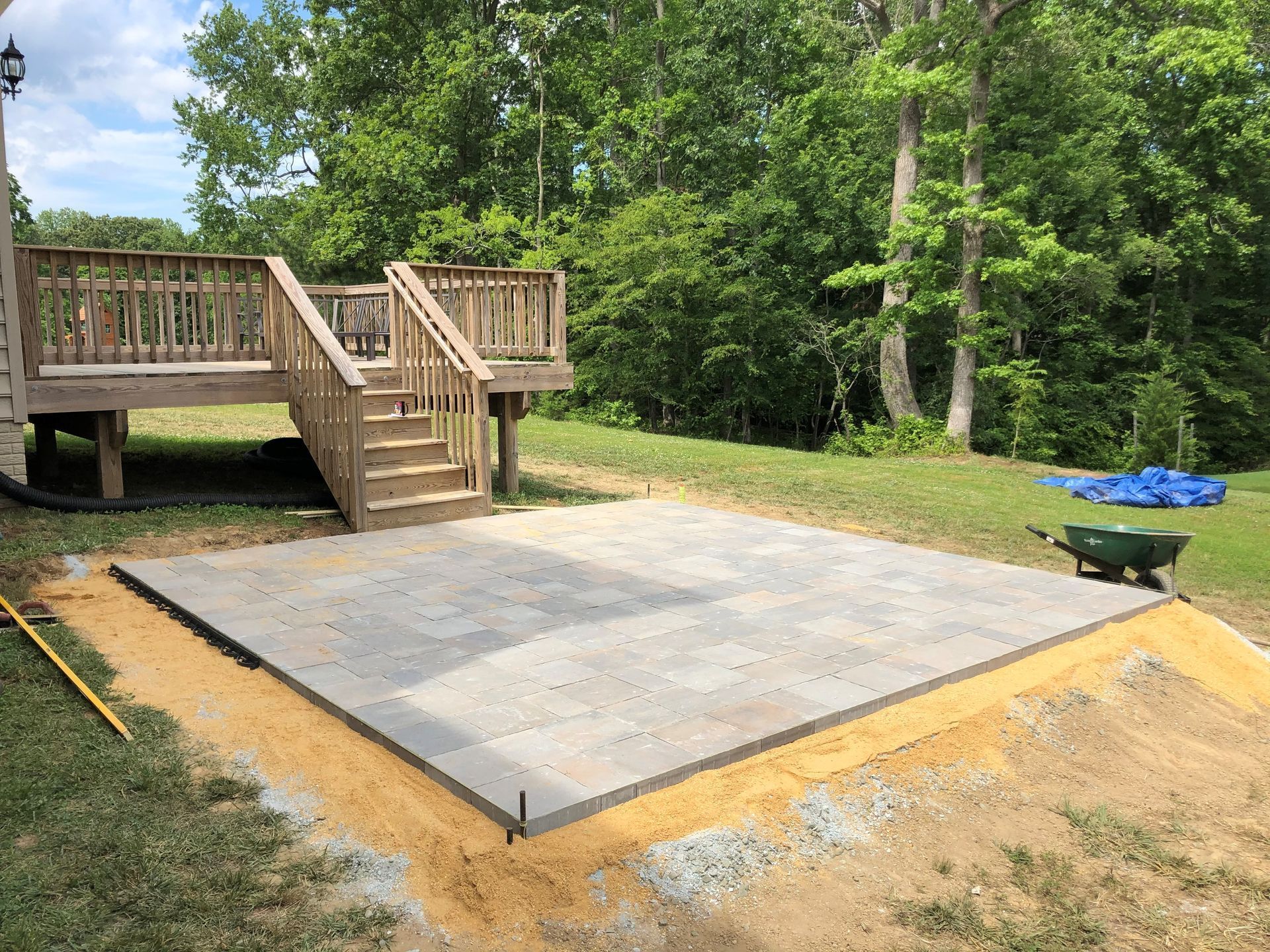 a concrete patio is being built in front of a wooden deck .