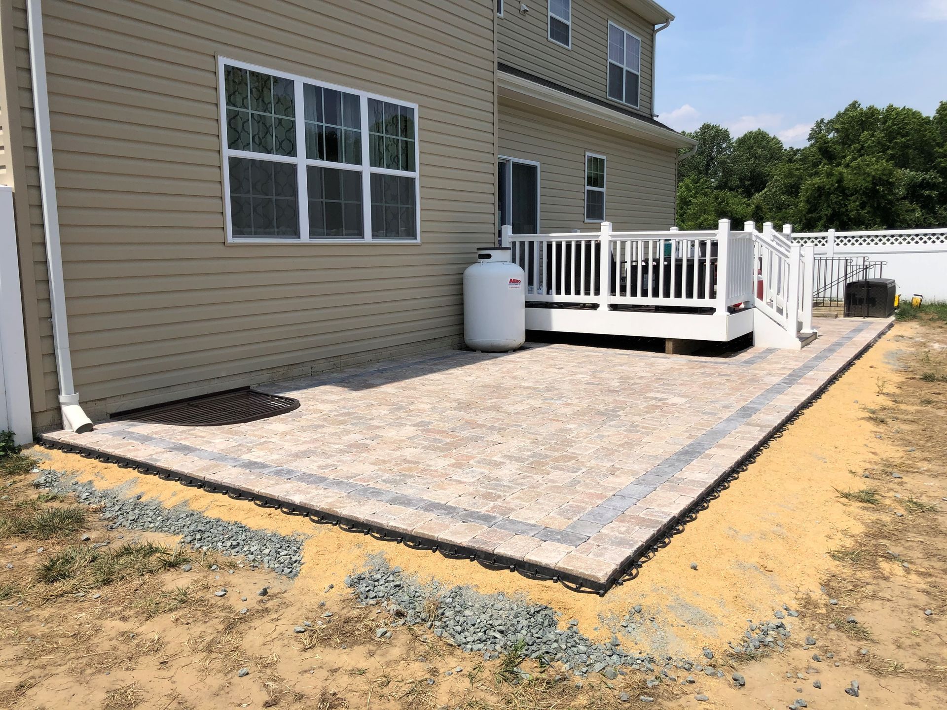 the backyard of a house with a patio and a deck .