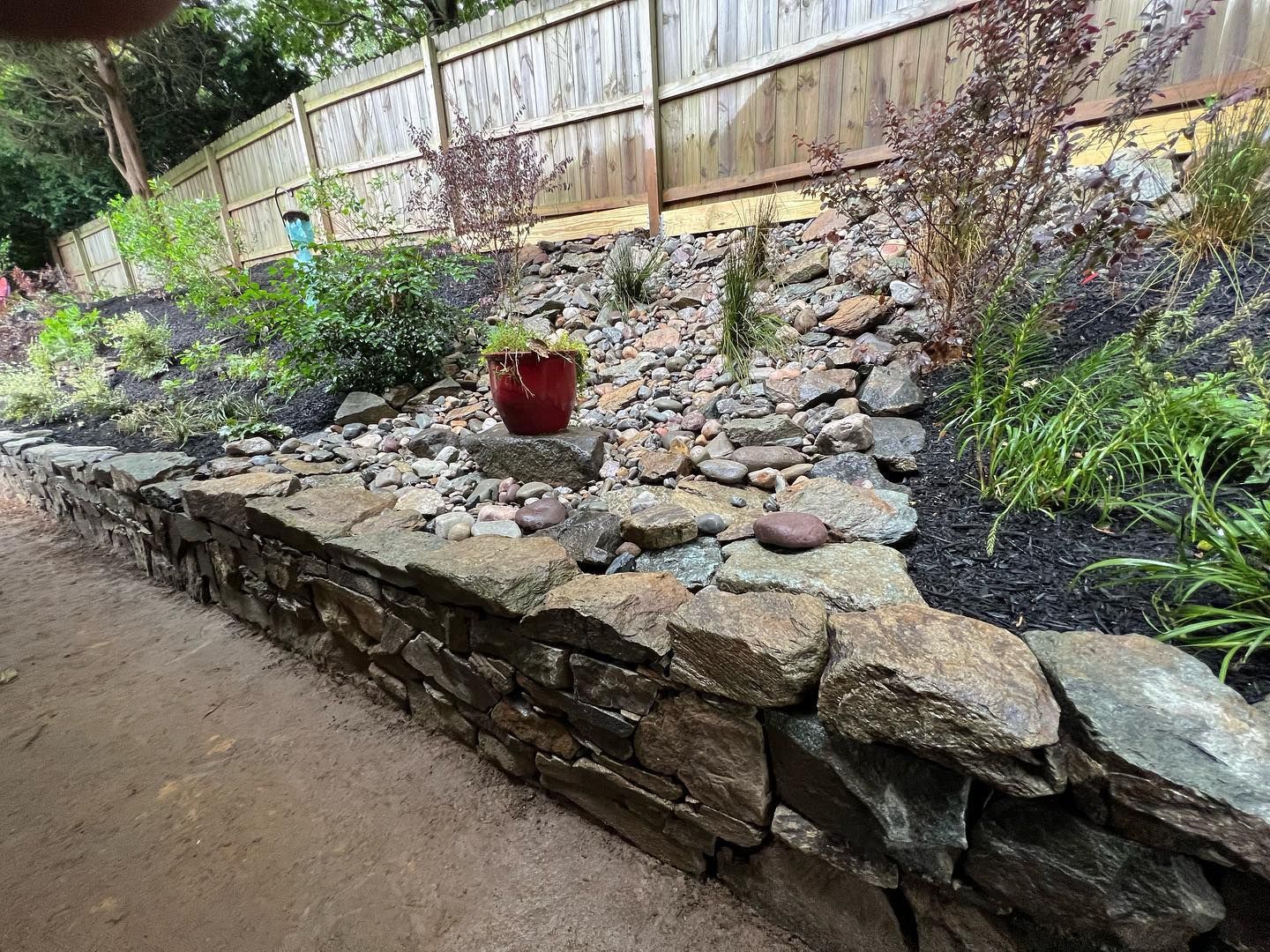 a stone wall with a potted plant in the middle of it .
