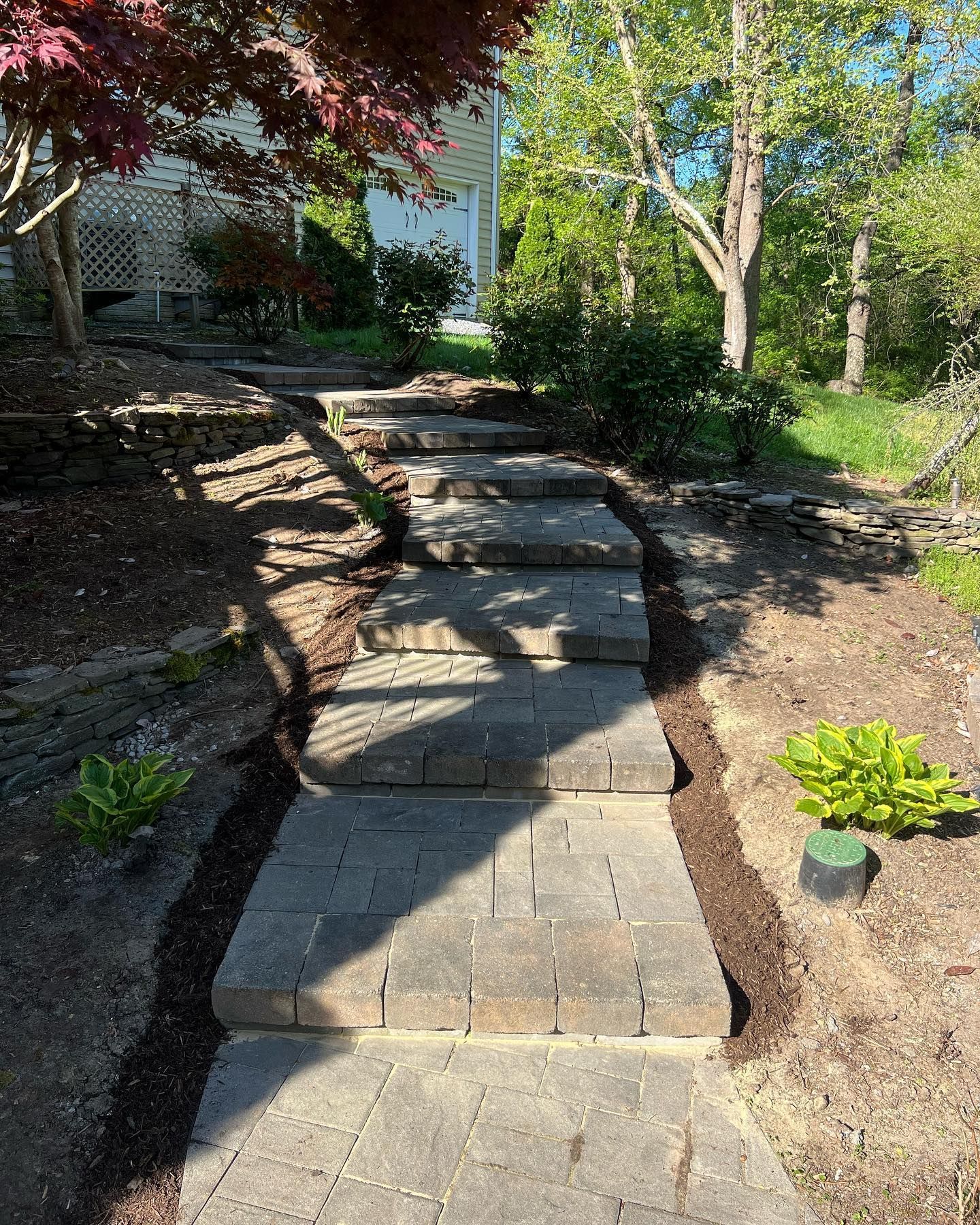 a stone walkway with steps leading up to a house .