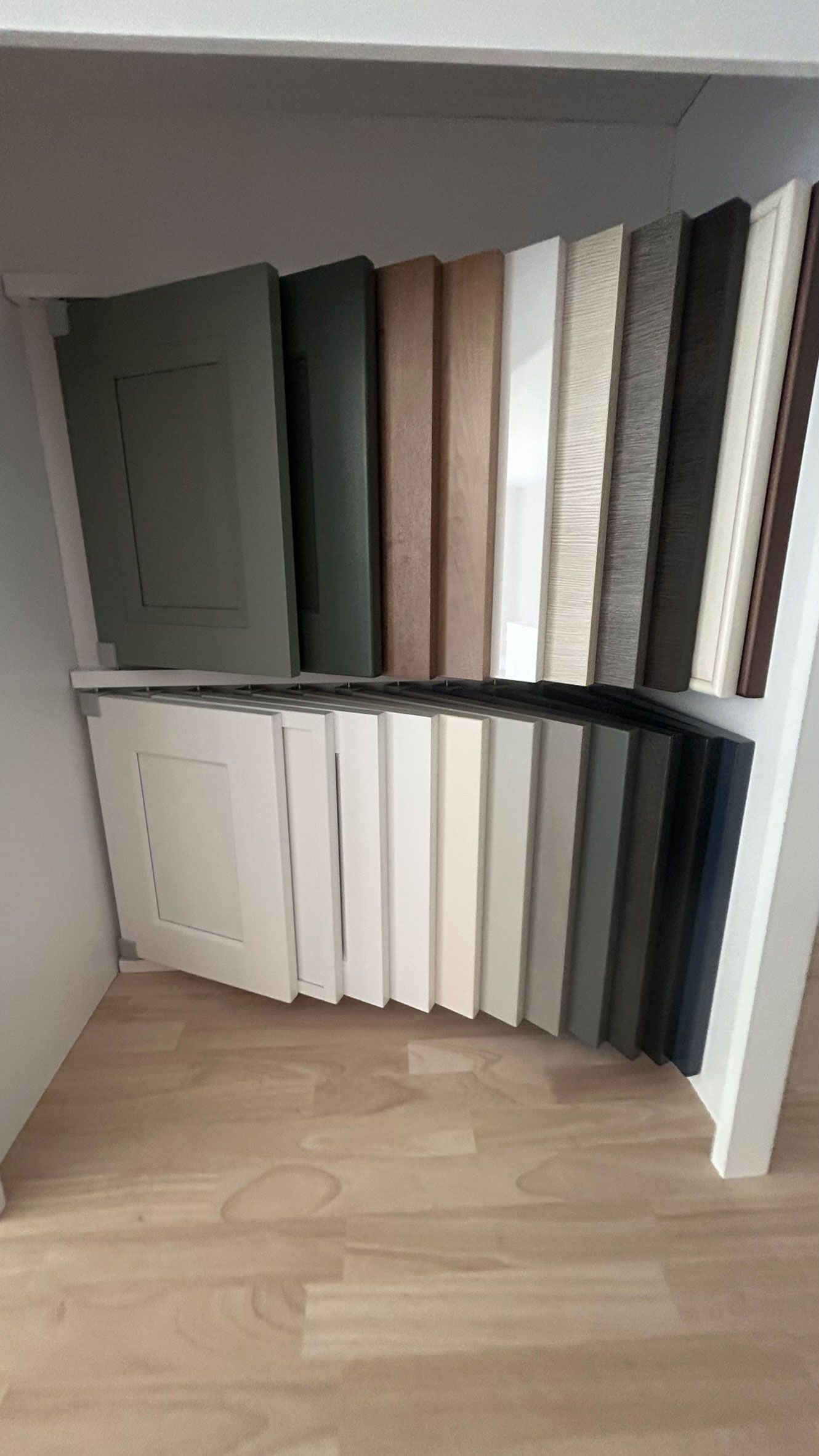 Cabinet door color samples are displayed in a showroom setting.