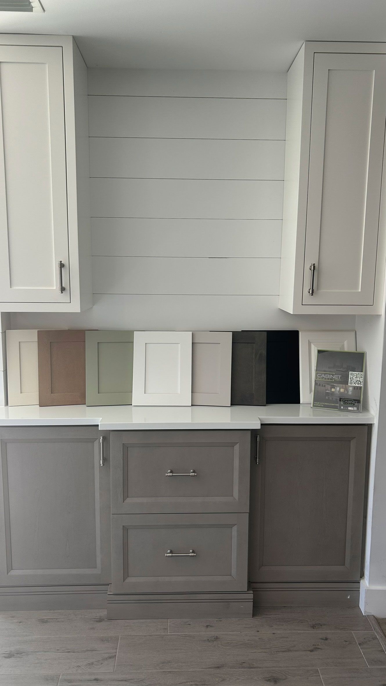 Kitchen cabinetry with color samples. Gray lower cabinets, white upper cabinets. Shiplap backsplash.