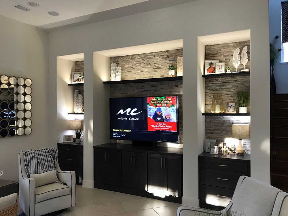 A living room with a large flat screen tv on the wall.