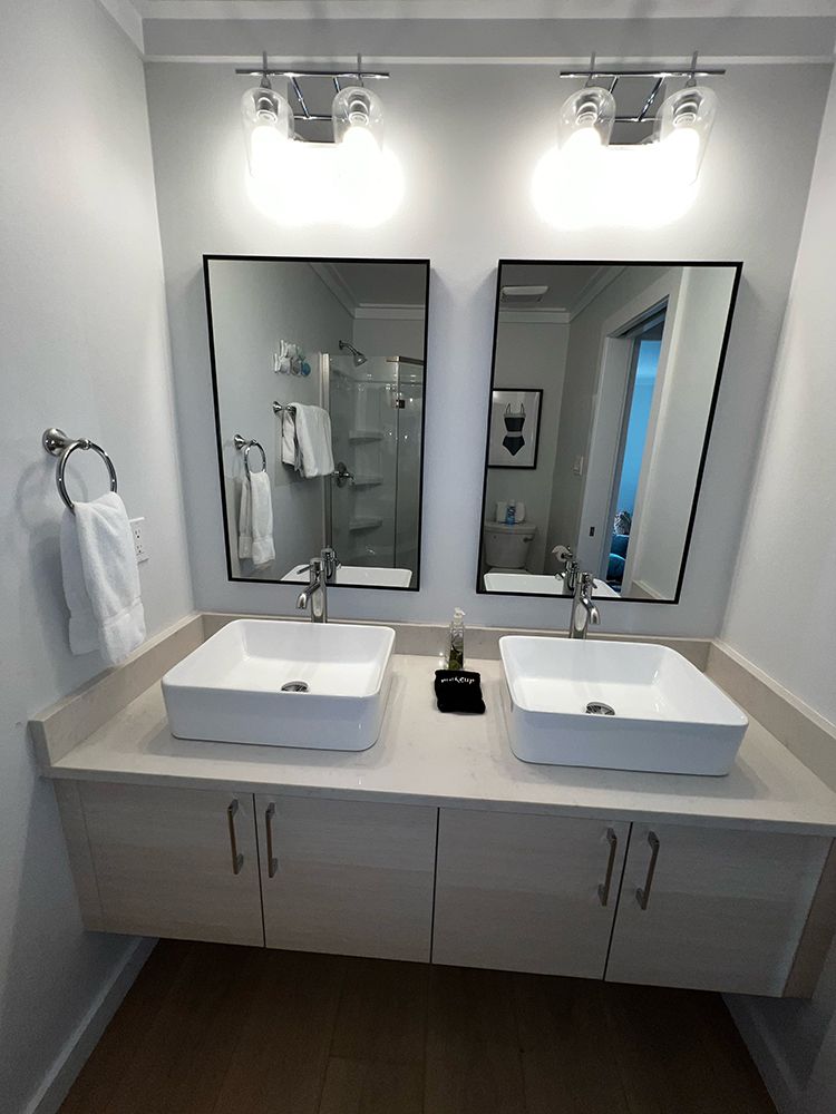 A bathroom with two sinks and two mirrors