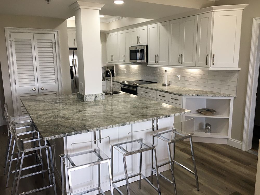 A kitchen with white cabinets and granite counter tops