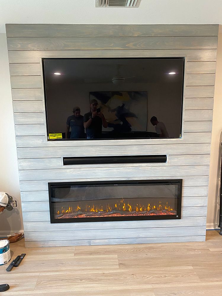 A living room with a fireplace and a flat screen tv.