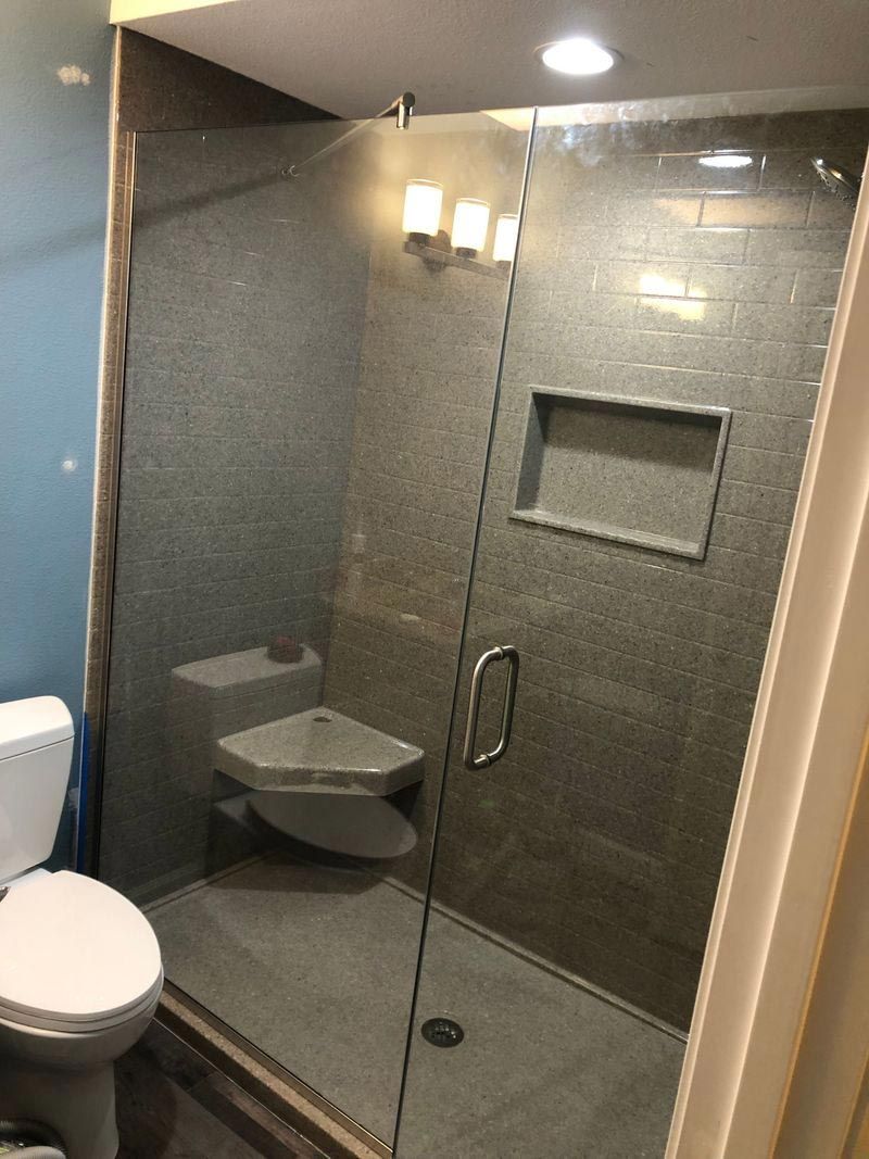 A bathroom with a toilet and a shower with a glass door.