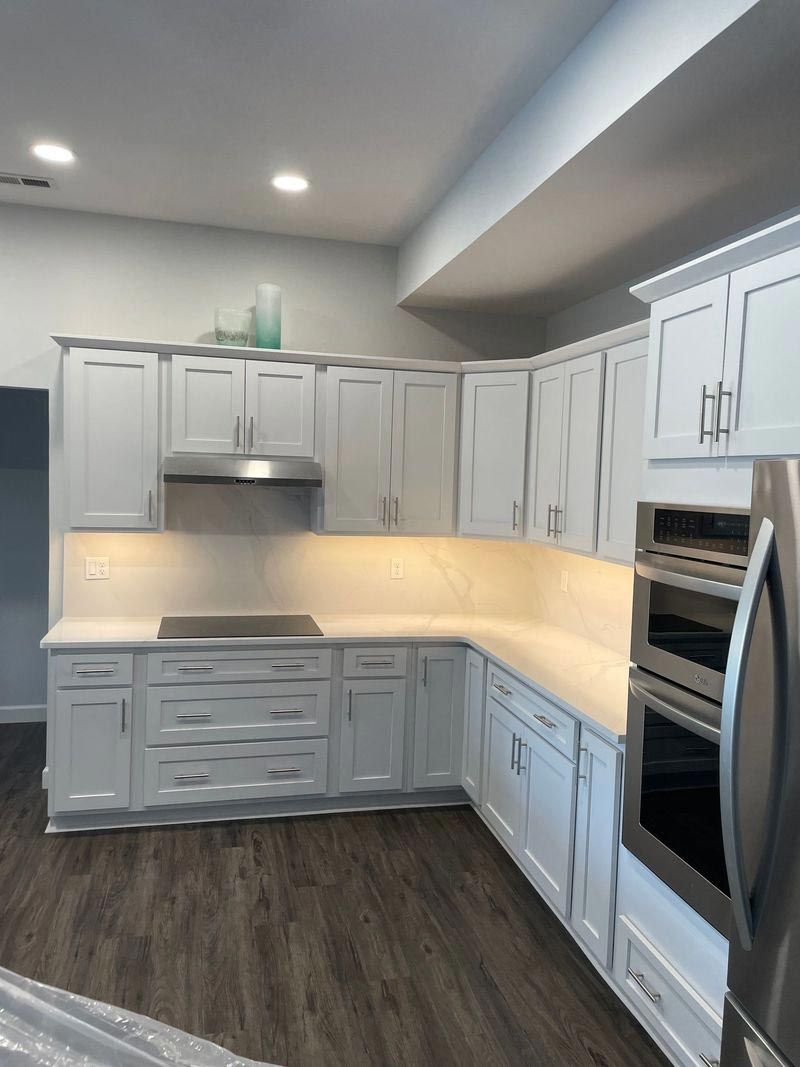 A kitchen with white cabinets and stainless steel appliances