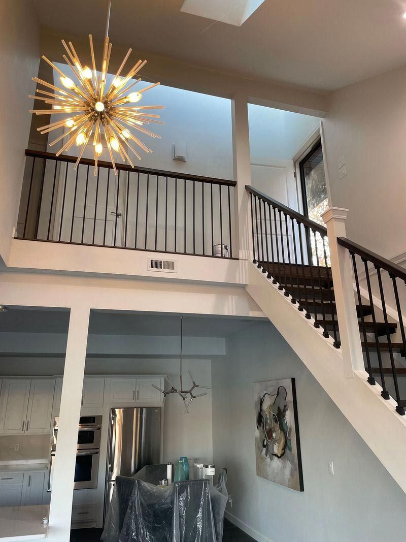 A staircase in a house with a chandelier hanging from the ceiling.
