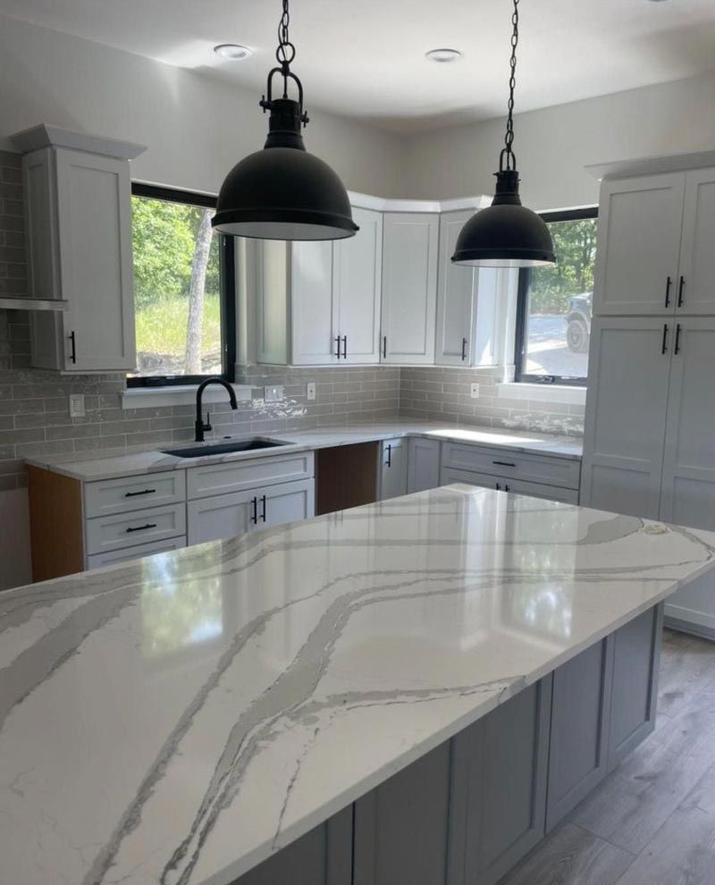 A kitchen with white cabinets and a white counter top