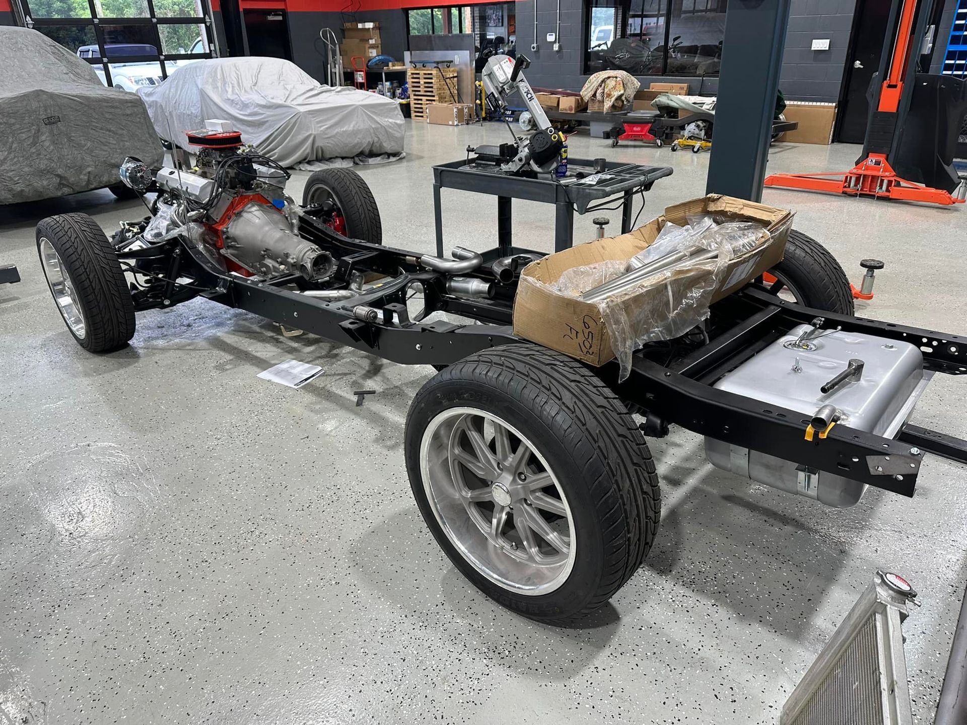 A car chassis is being built in a garage.