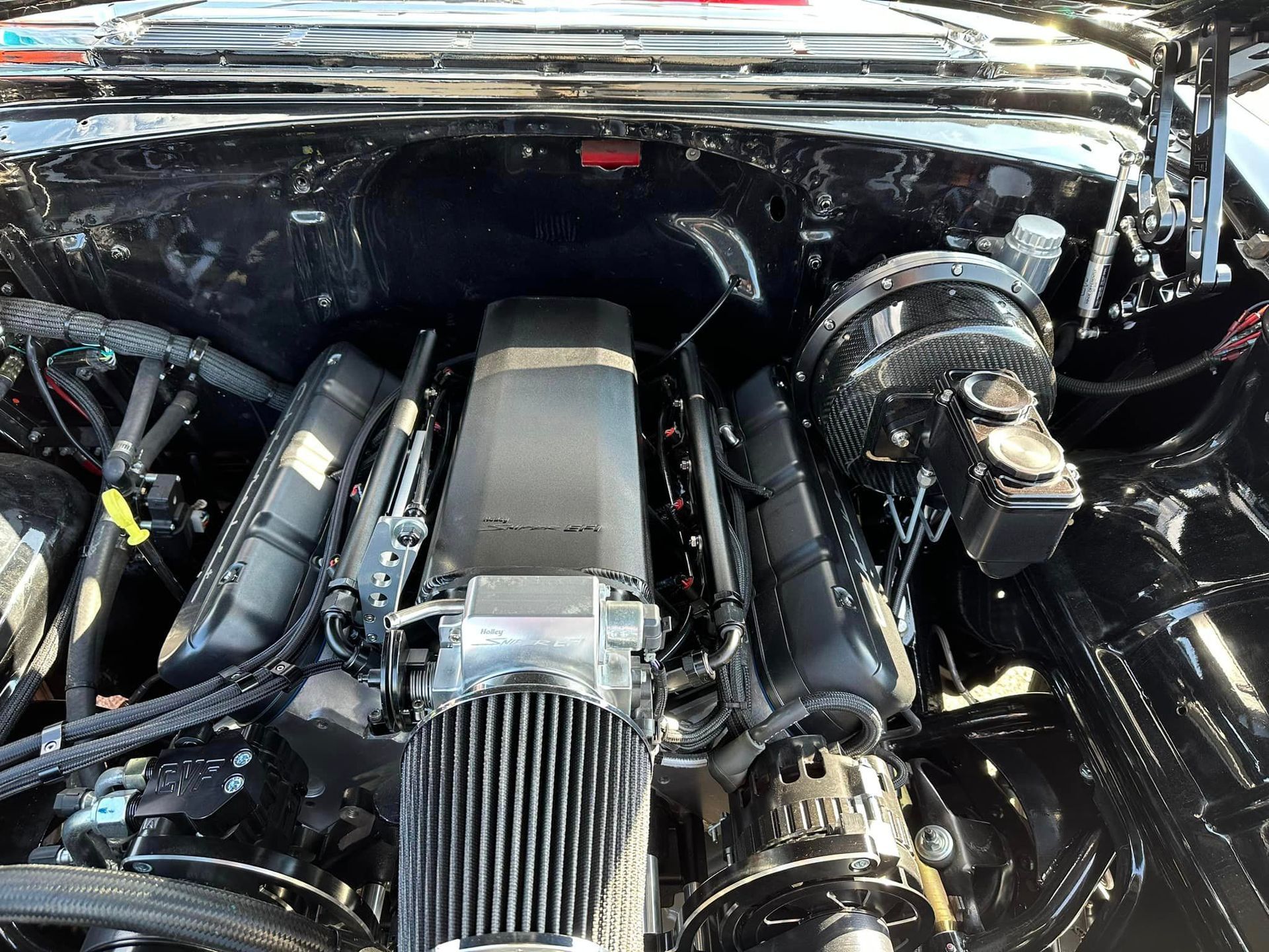 A close up of the engine of a black car.