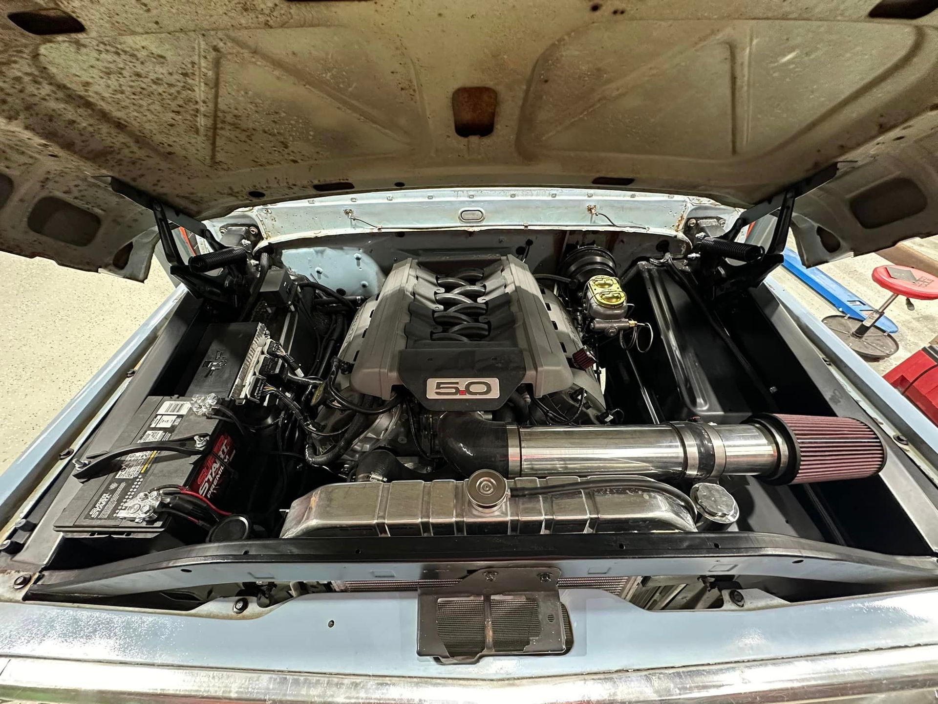 The hood of a car is open and the engine is visible.