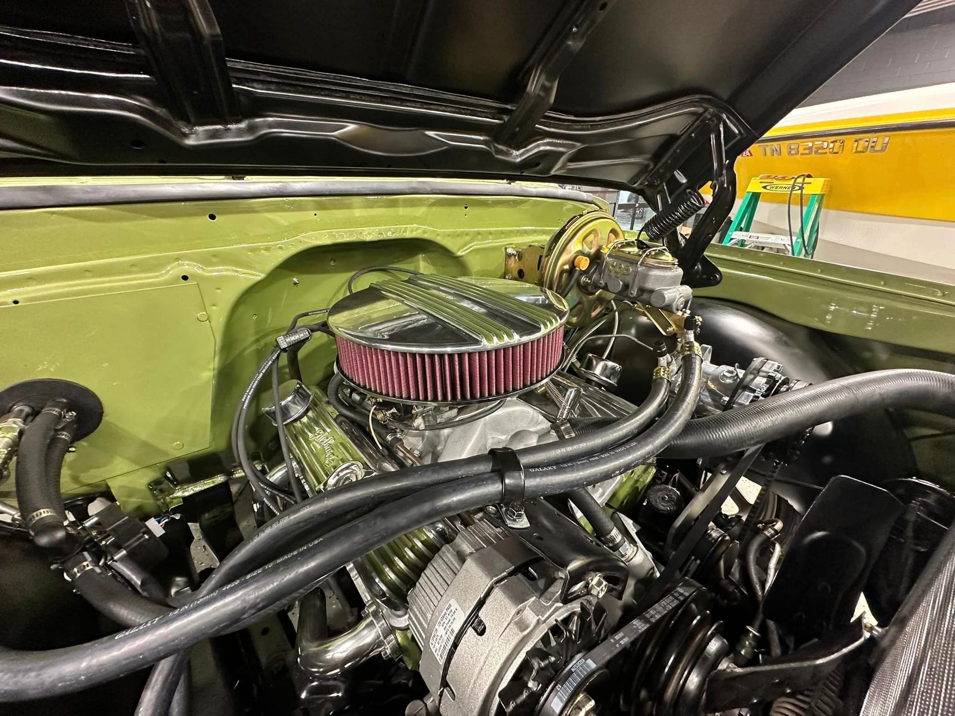 A close up of a car engine with the hood up.