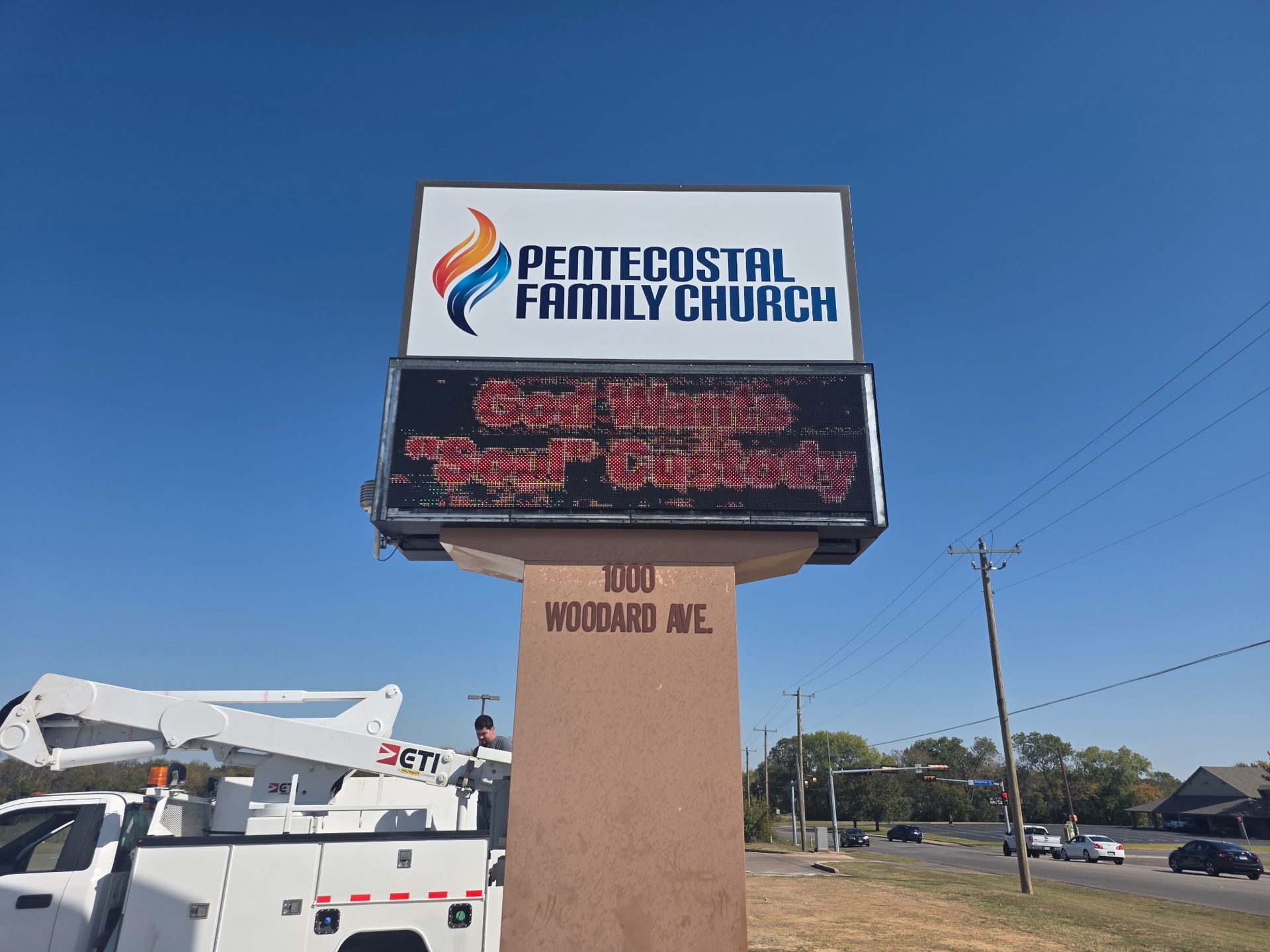 Pentecostal Family Church sign on a roadside, with a digital marquee and a clear blue sky.