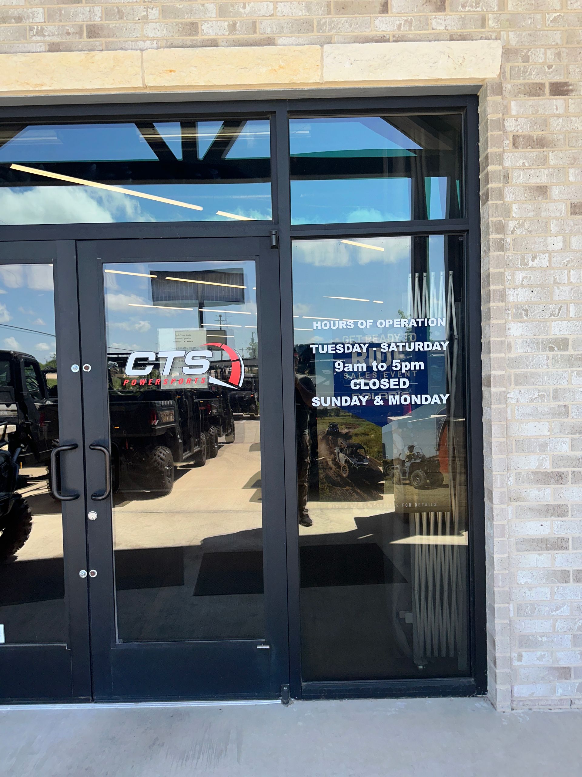 Glass storefront entrance with double black doors and white signage on the right pane.