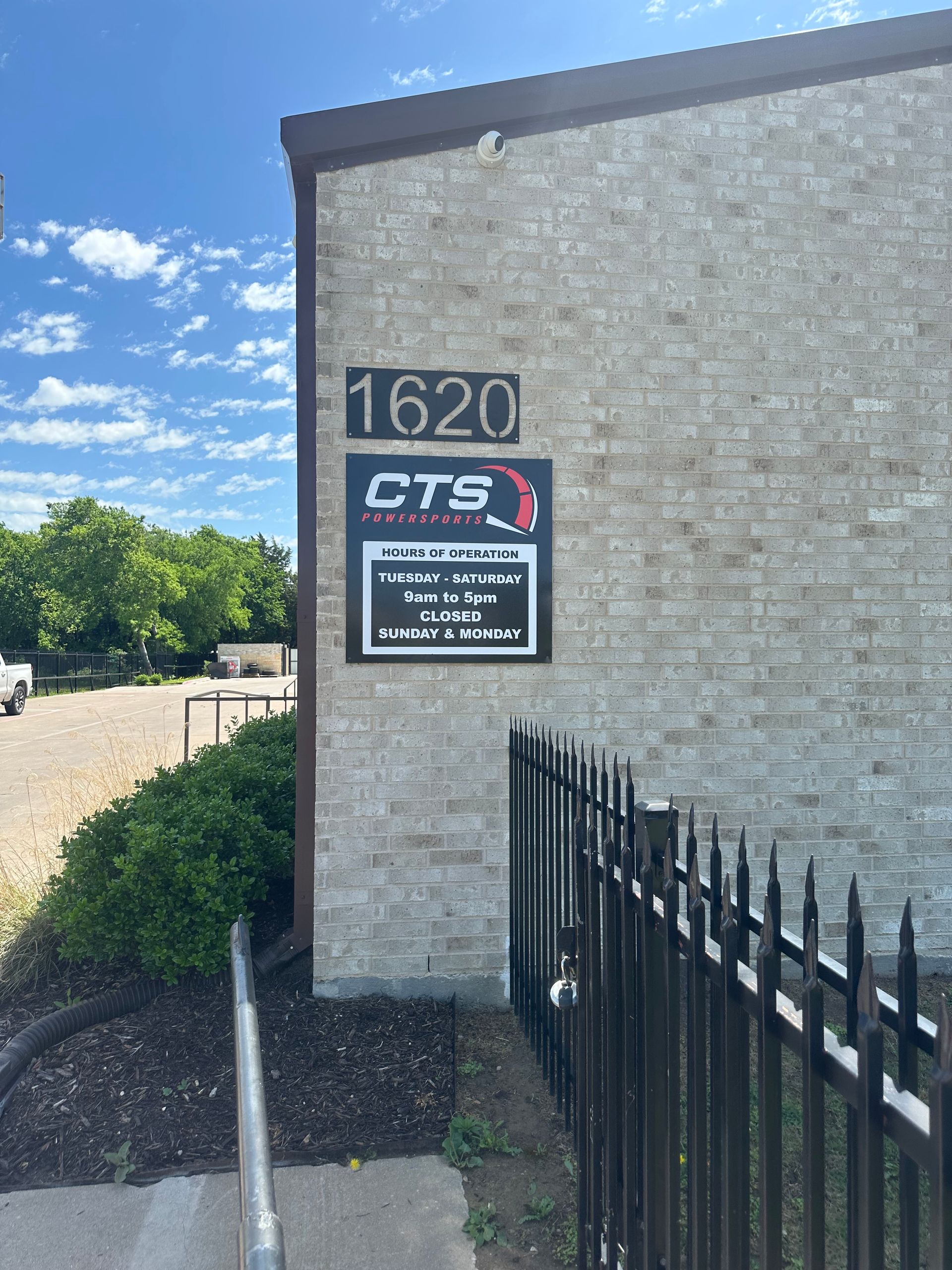 Exterior wall with 1620 address plaque and CTS sign beside a black metal fence.