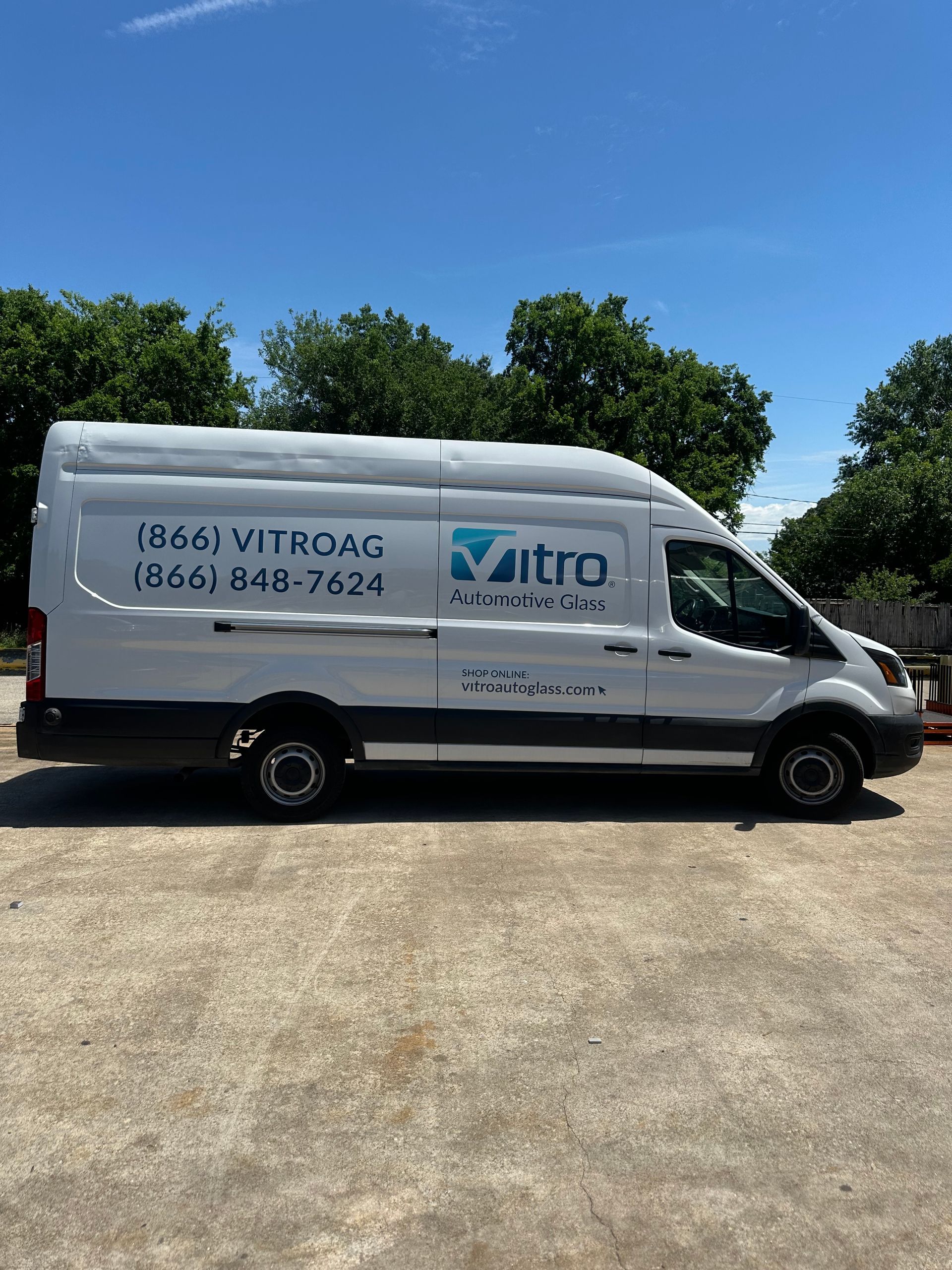 White Vitro service van parked outdoors on a sunny day with phone number and logo on the side