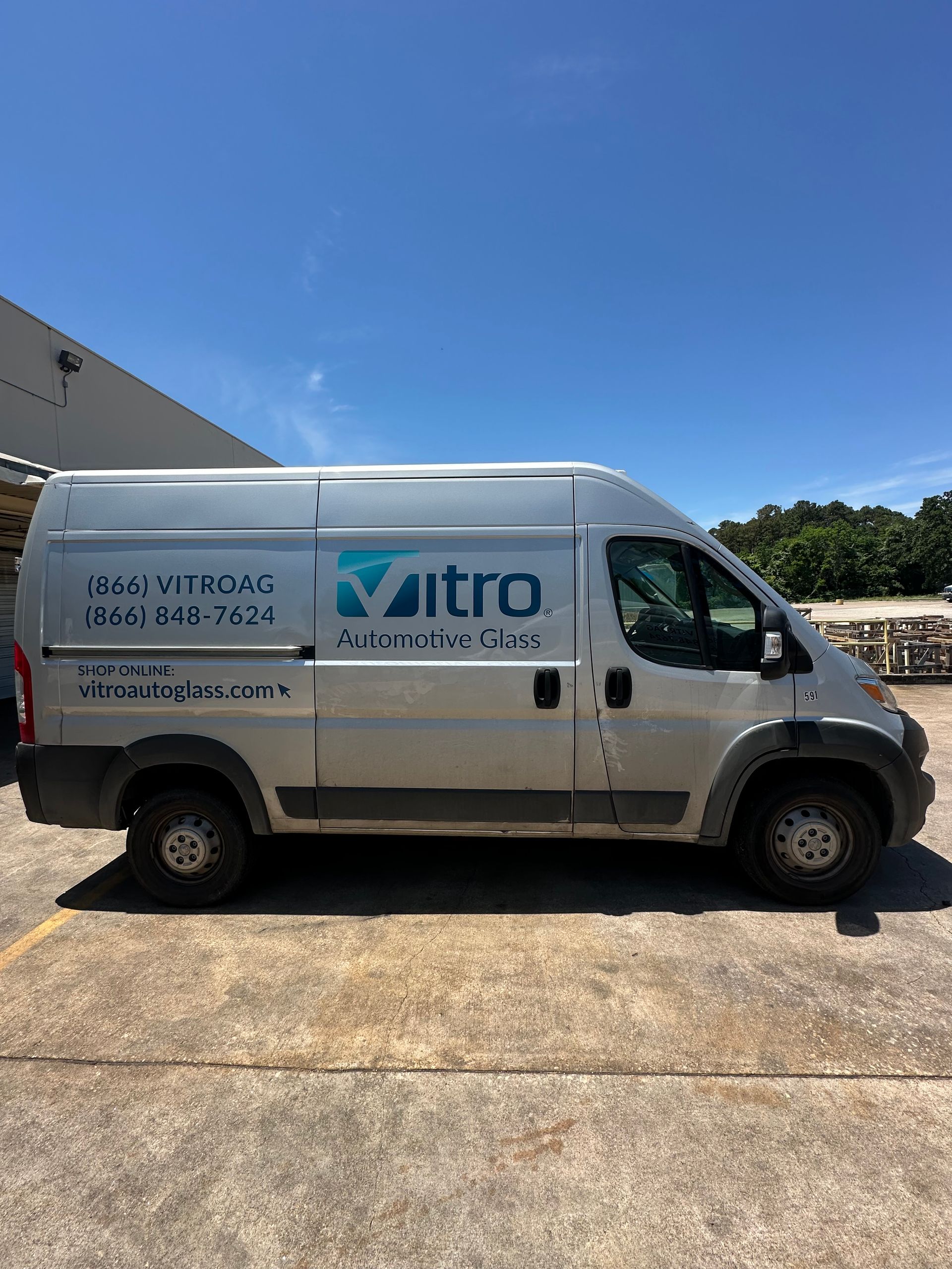 White Vitro service van parked on a sunny driveway against a blue sky.