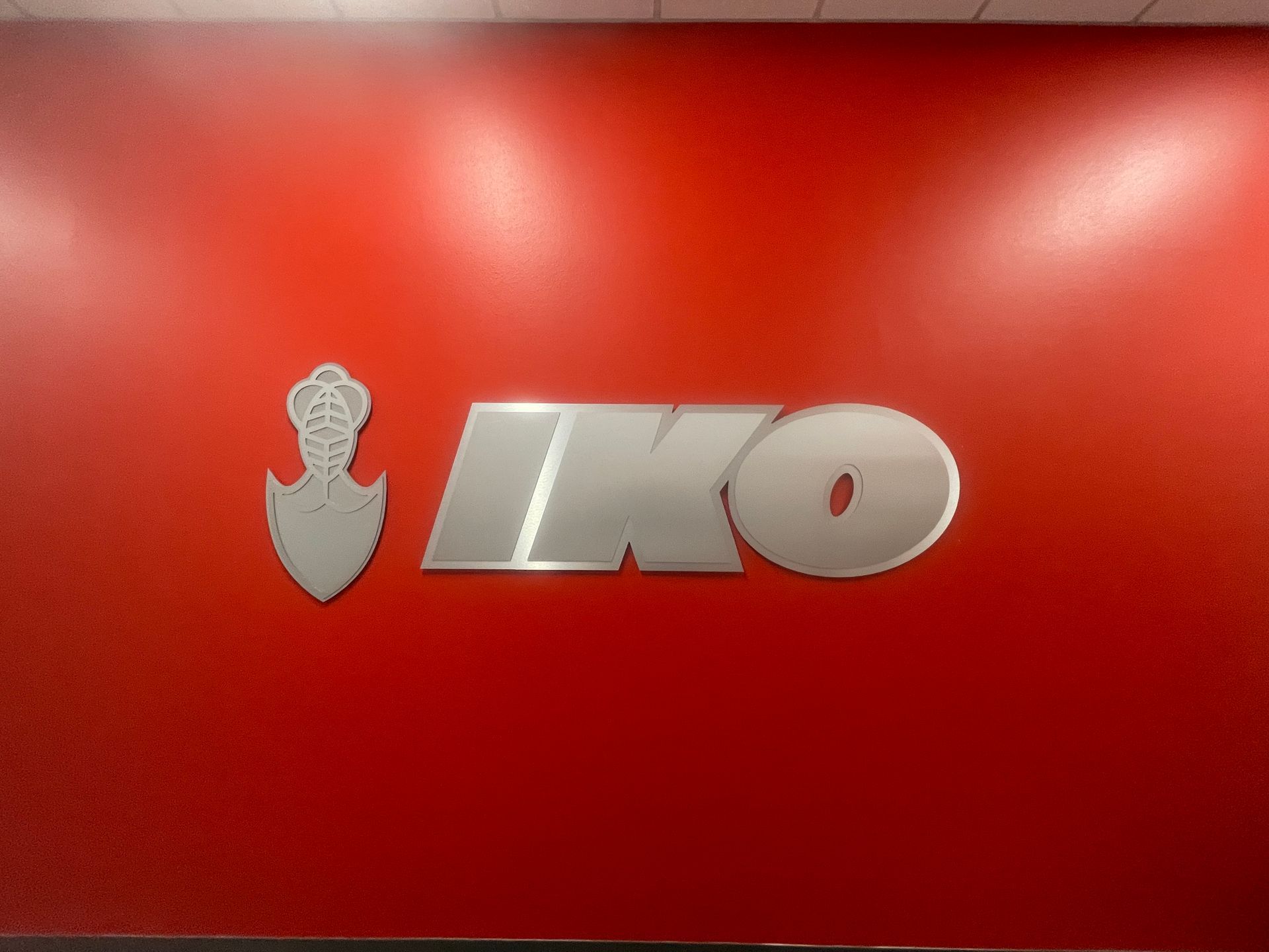 Silver IKO logo on a red background