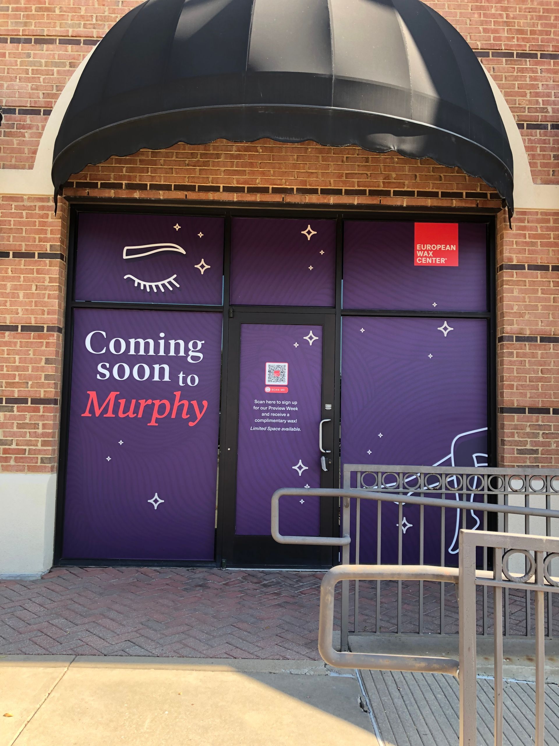 Purple storefront with “Coming soon Murphy” signage under a black awning, with bike racks in front.